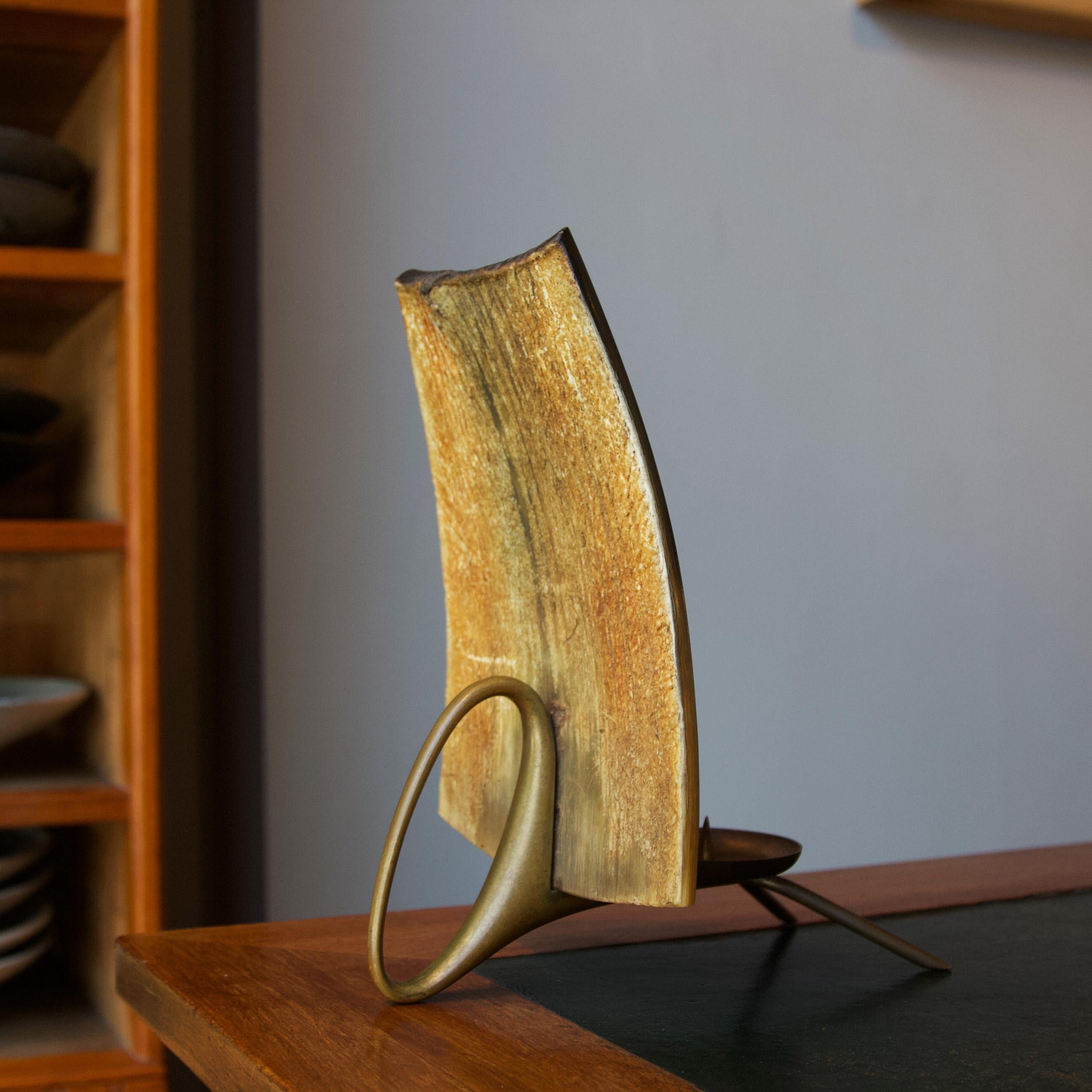 A striking brass tea light holder with natural horn screen made by Carl Auböck III, c.1949. 

The front of the horn screen is a rich amber colour with deep and tactile vertical striations. The reverse of the screen is a smoother surface, highly