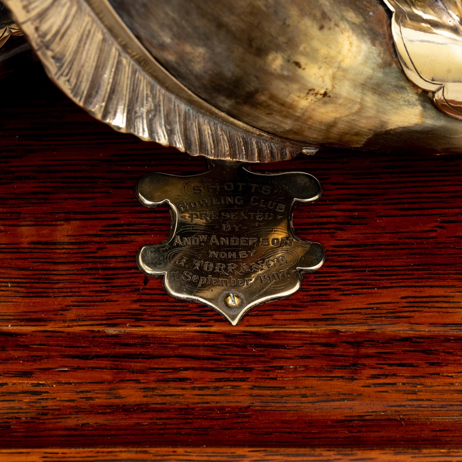 Circa 1909 English silver plate horn and dolphin inkwell with bell, double inkwell on wood base with plaque dated 1909. Made in England. Cleaned and polished. Please note of wear consistent with age.