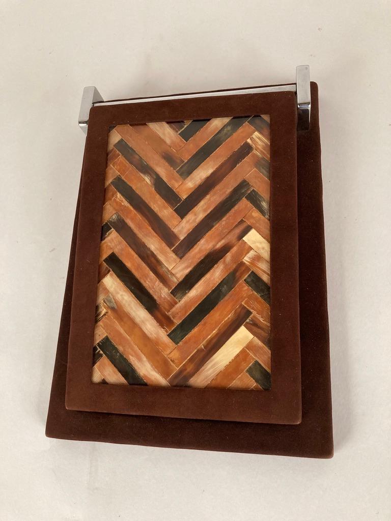 Die schöne, mit Hornintarsien versehene Platte, eingefasst in tief burgunderrotes Wildleder, schwingt an verchromten Scharnieren nach oben. Ein wunderschönes Stück der bekannten Designfirma The Rudolph Collection, die in Miami und NYC ansässig war.