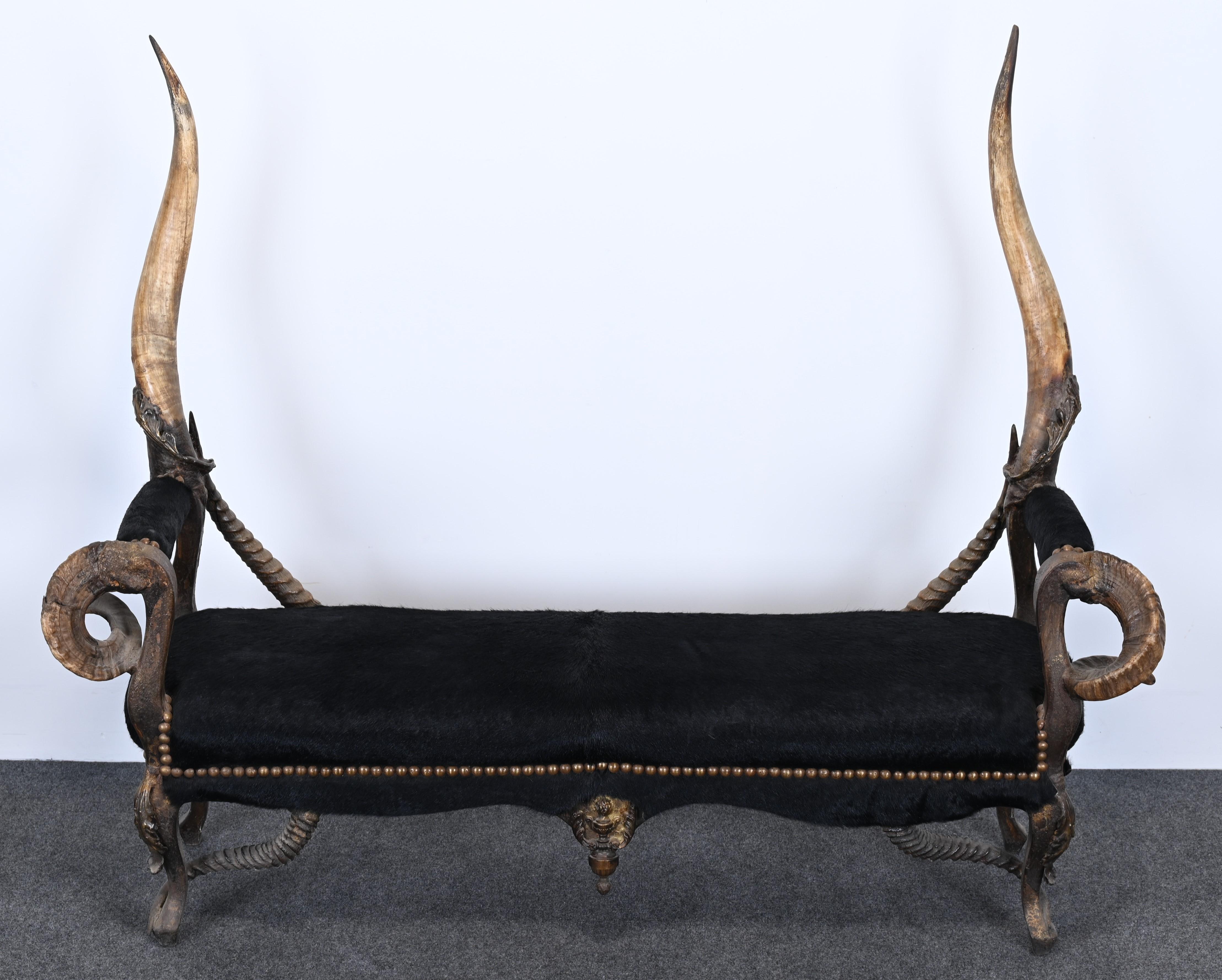 A large exotic and rustic horn bench with ormolu hardware. This amazing bench was designed and made by Michel Haillard of France. Intertwining horns, brass nailheads, and covered animal hide seat combine in a masterful design to create this Louis XV