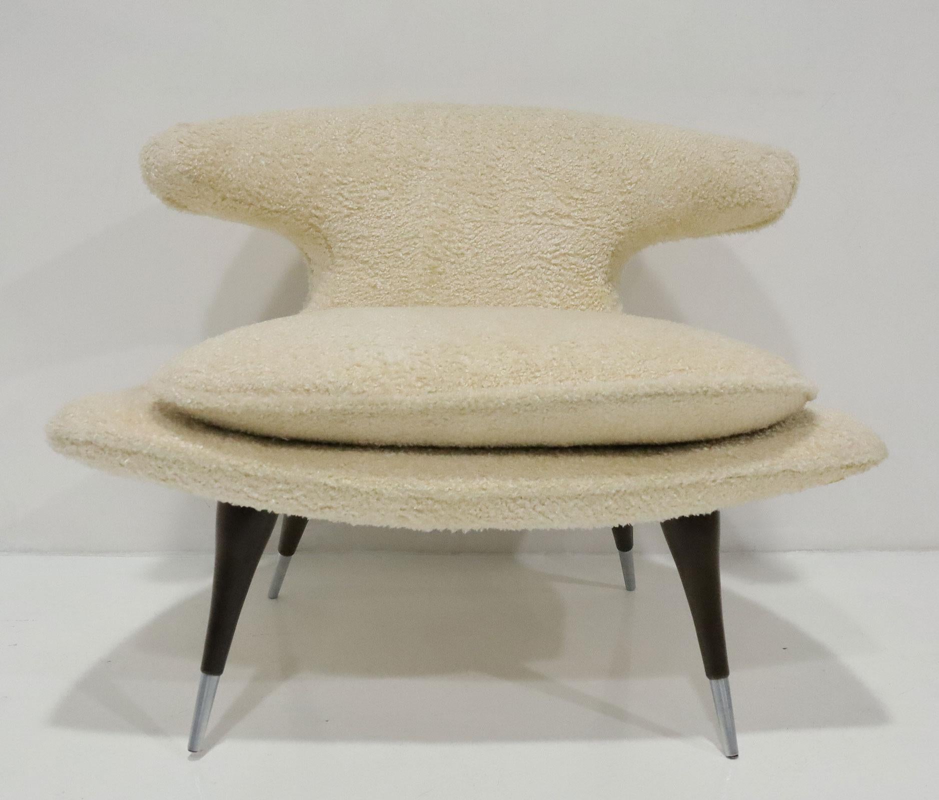 The archetypal horn-shaped arms are both visually captivating and wrap the sitter's back with there alluring curves creating a uniquely comfortable sitting experience. Set atop minimalist tapered legs forged from solid American walnut with