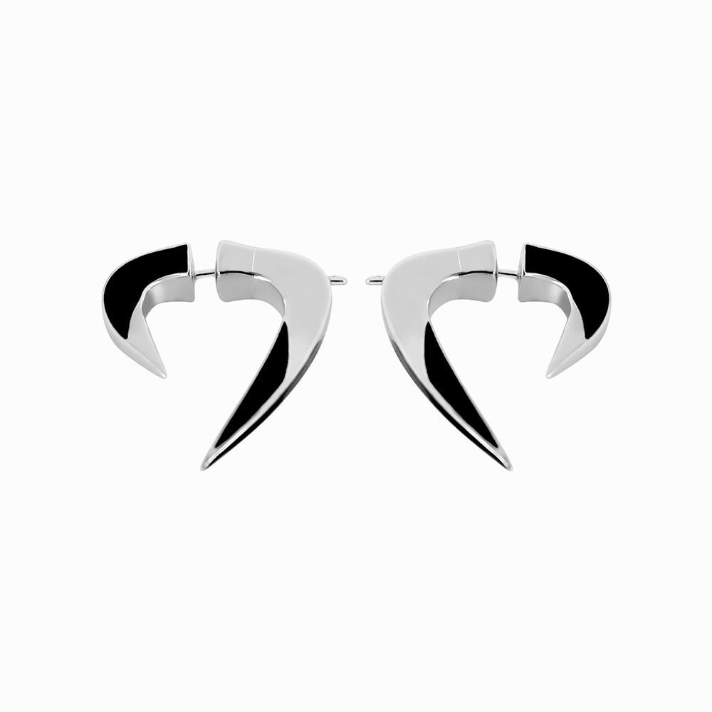 Ethno-rock unisex style earrings in sterling silver and black enamel.
The design is inspired by the shape of the horseshoe nails and the horned-body ornaments popular in tribal traditions. They are shaped like two sided tusks front and back,