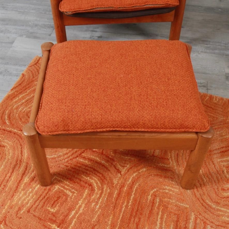 Teak armchairs and ottoman from the 1960s that have new reupholstered cushions in a cool burnt orange. Frames are solid teak and the chocolate fabric stretchers underneath the cushions are original and in decent shape. This a nice Danish set that