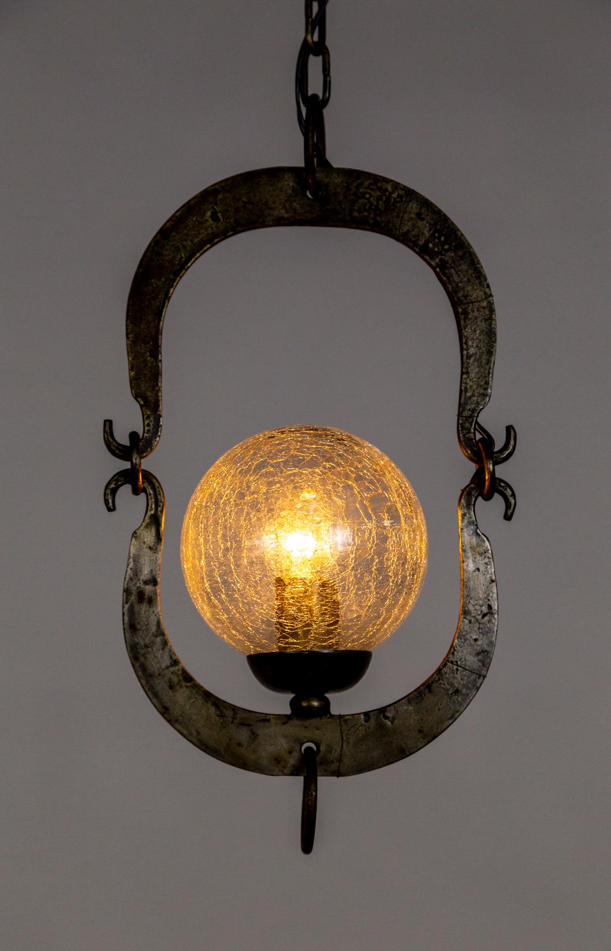 This unique, antique pendant light with custom, period glass, has a timeless look. The aged, forged metal has a lovely patina and hand-made texture; in an understated, elegant design with a hanging ring detail. The 