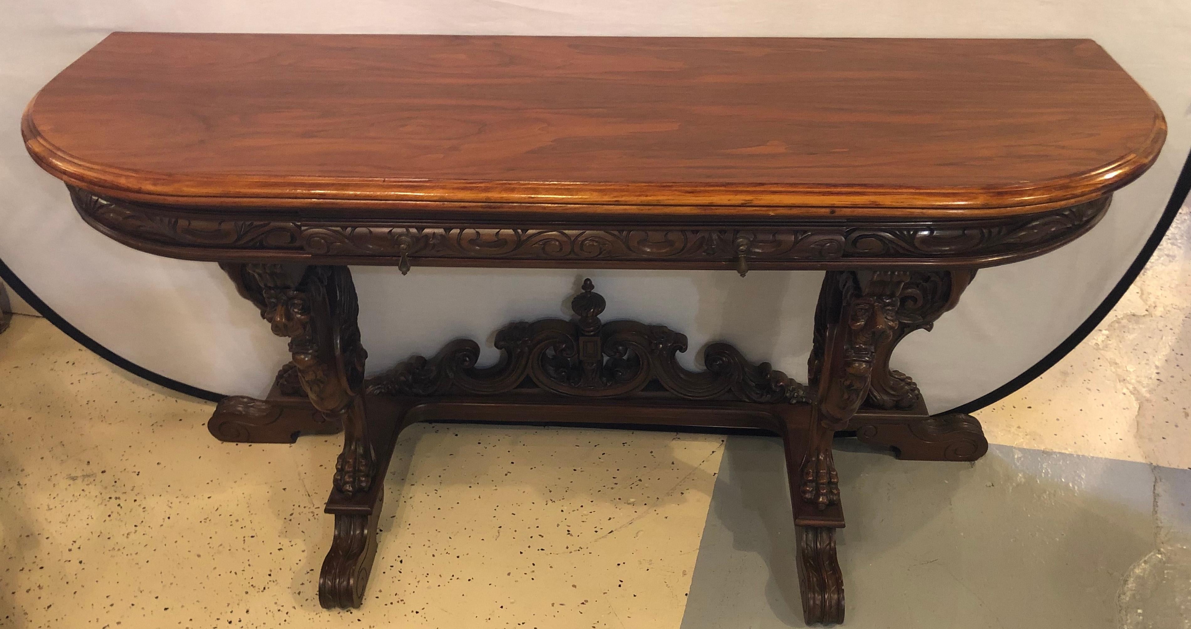 Late 19th or early 20th century Horner Brothers quality flip top dining table with 4 full bodied winged griffins. This wonderfully carved library or dining table sits up against any small wall and then magically flips open to seat eight or ten for