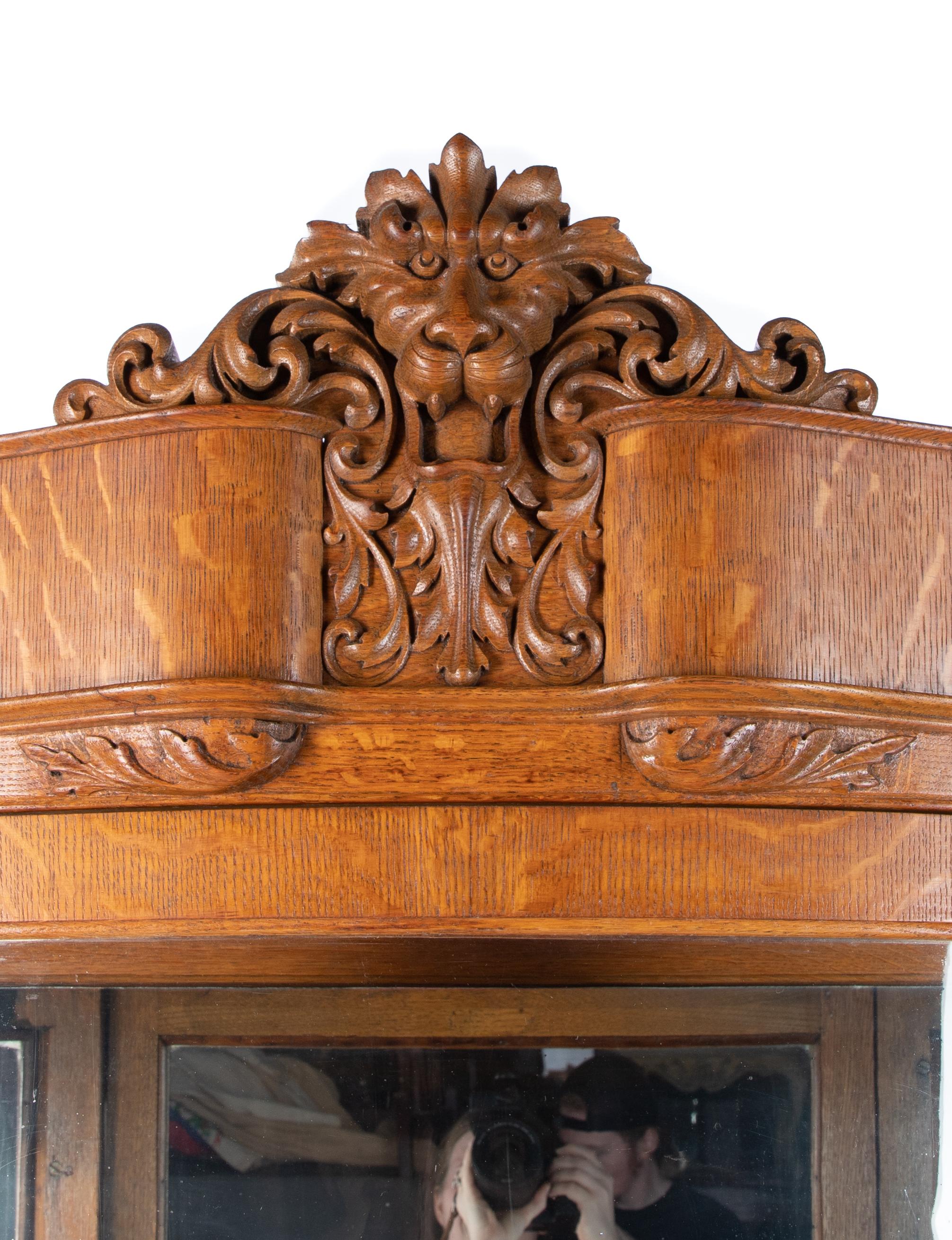 Offering this stunning tiger maple Horner cabinet. Sitting atop 4 paw feet on casters it rises upward. On the front of the curved body two columns rise to the top. On top of the columns are tigers heads, and one tiger head in the center above the