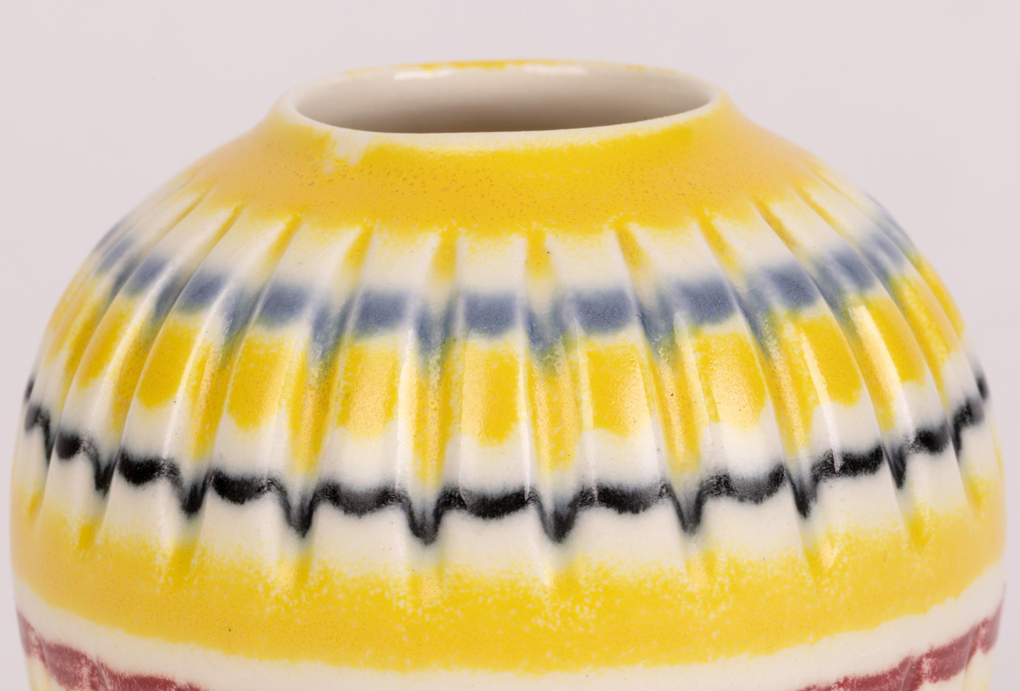 Eine sehr stilvolle, handbemalte Vase aus der Mitte des Jahrhunderts mit dem Regenbogenmuster von Hornsea aus der Zeit um 1960. Diese fein gearbeitete Keramikvase steht auf einem schmalen runden unglasierten Fuß mit leicht vertieftem Boden und hat