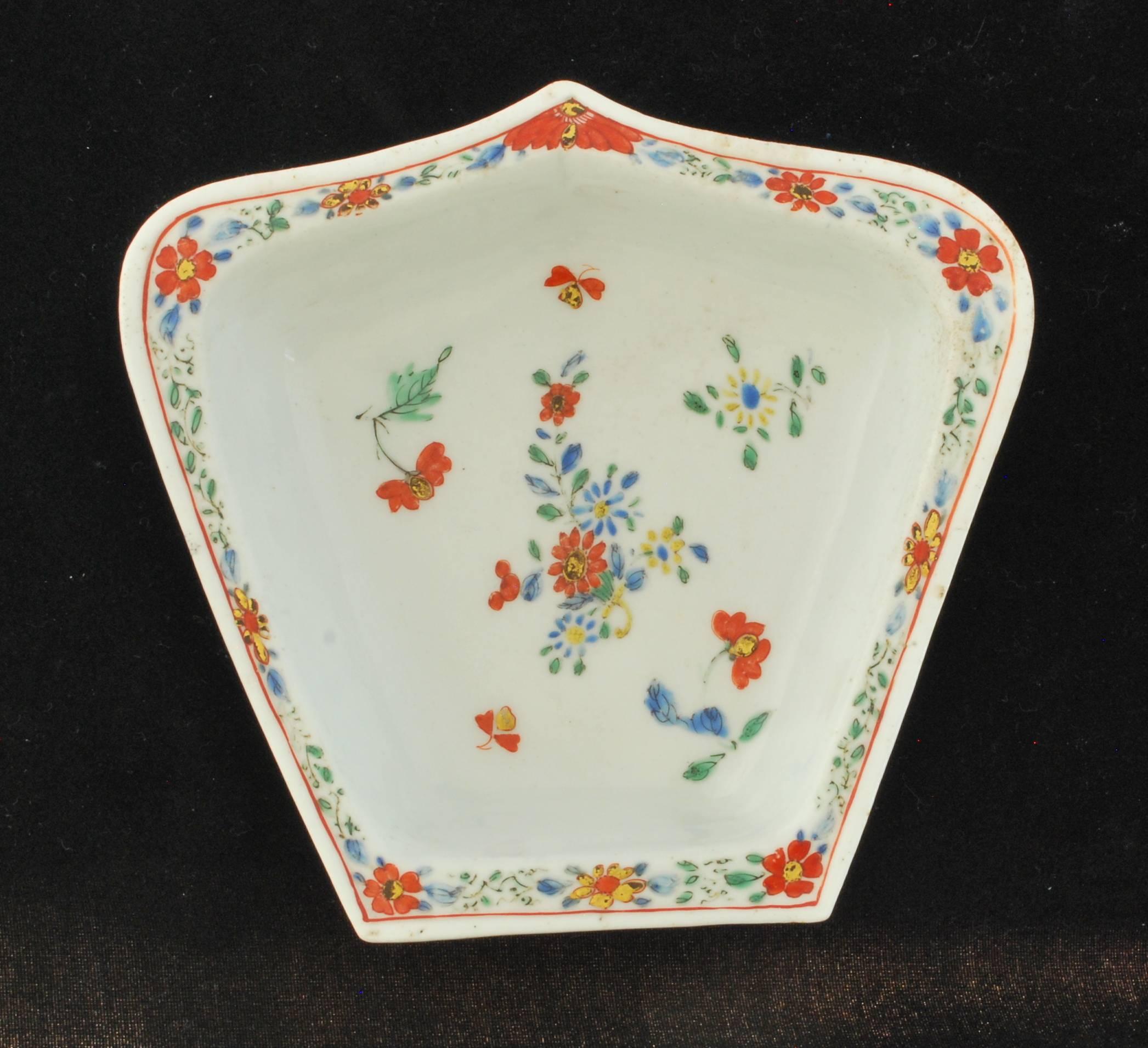 An ogival form dish, decorated after the Kakiemon. The dish is one from a presumed set of eight plus an octagonal central dish, all after a Kangxi hors d'oeuvre, sweetmeat, or condiment set, circa 1720, devised in form as a stylised eight-petalled