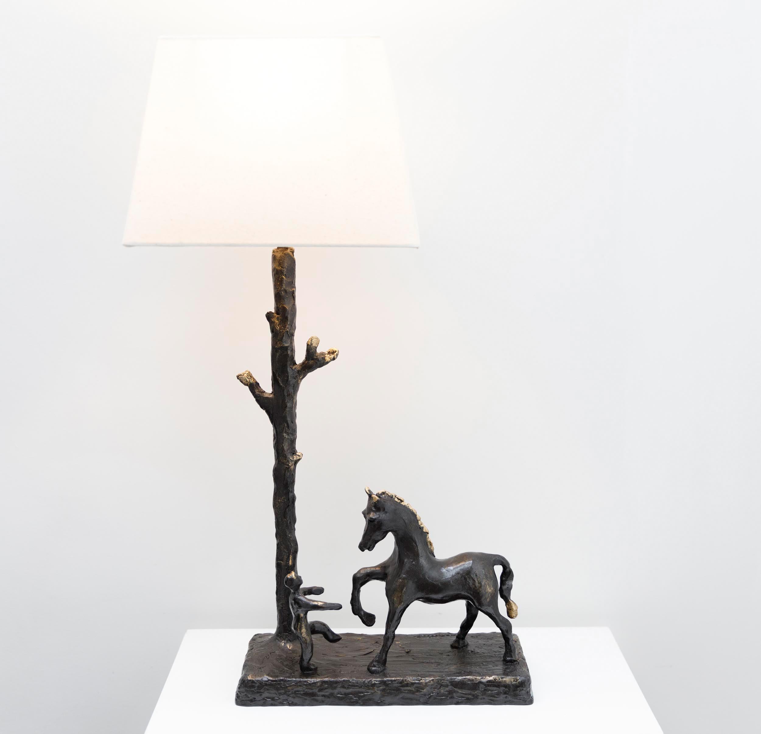 Last in the series of sculptural table lamps this one of a kind Boy & Horse hand crafted lamp is molded and cast in Resin. 
 A whimsical sculptural lamp of a boy and his horse playfully mimicking one another's movements in a captivating pose. The