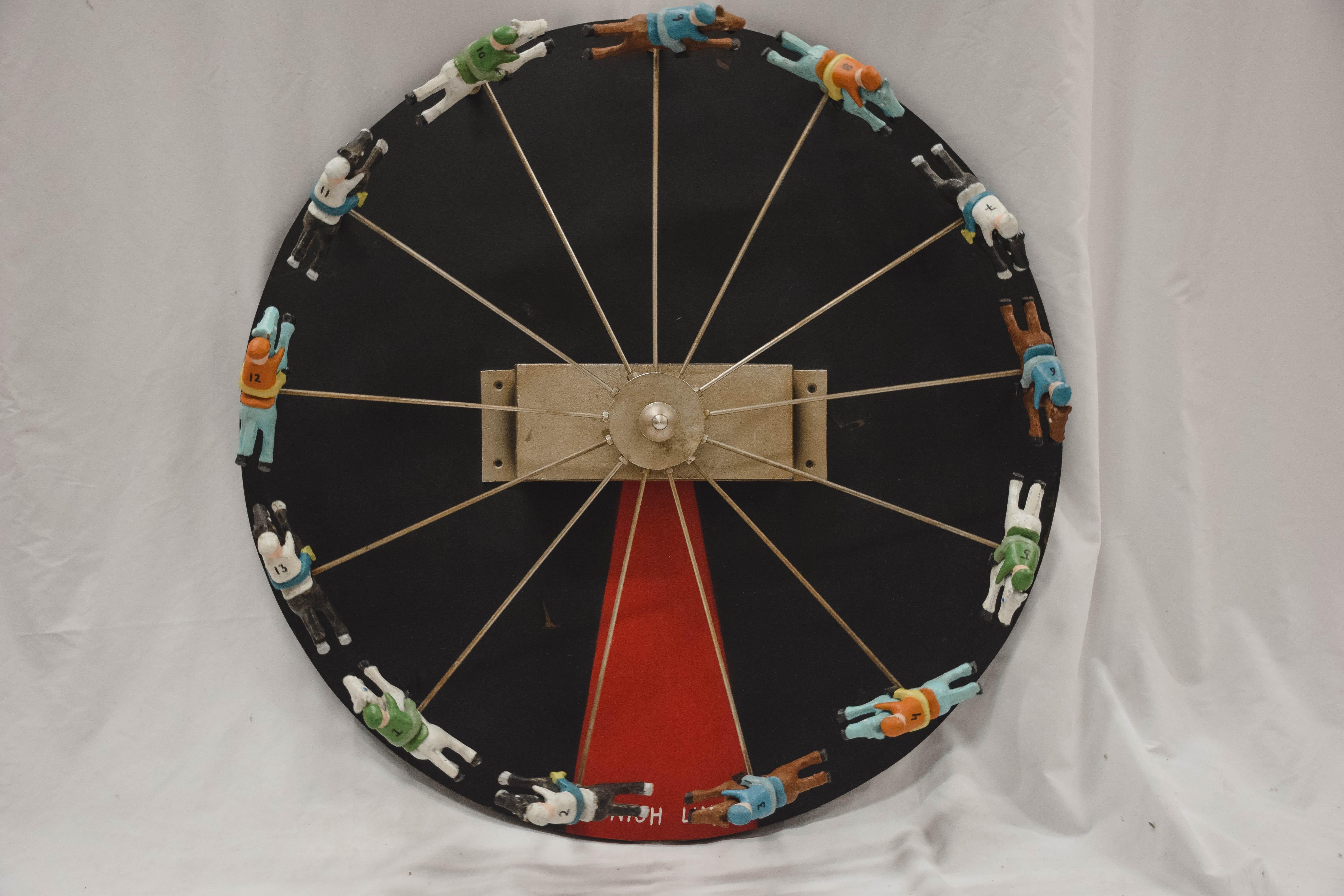 We love this horse and jockey spinning race game wheel and know you will too. The piece features thirteen colorfully painted cast metal horse and jockey combinations on the spokes of a metal wheel. They race above a round black, red and white