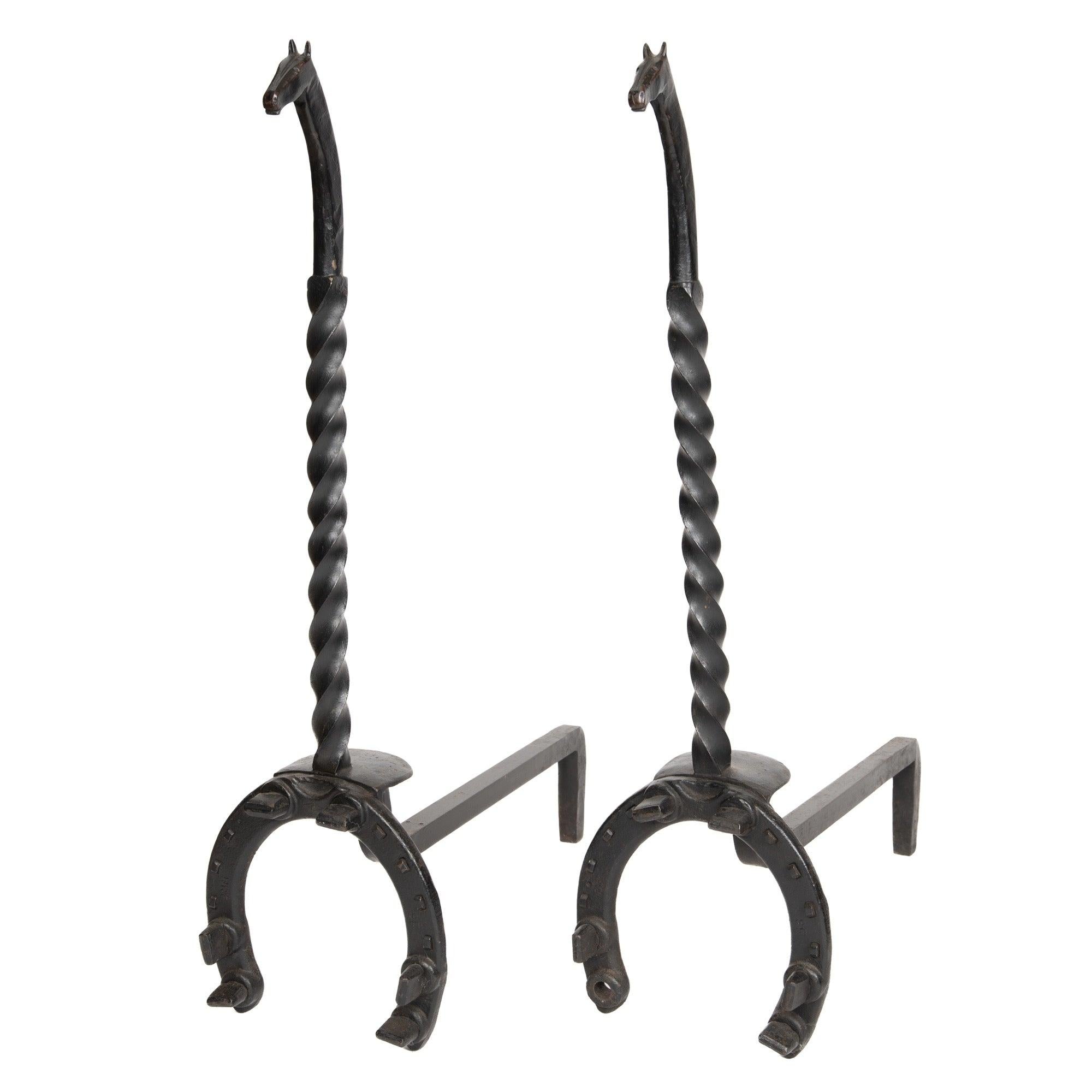A pair of andirons in steel depicting a horses head and shoe
