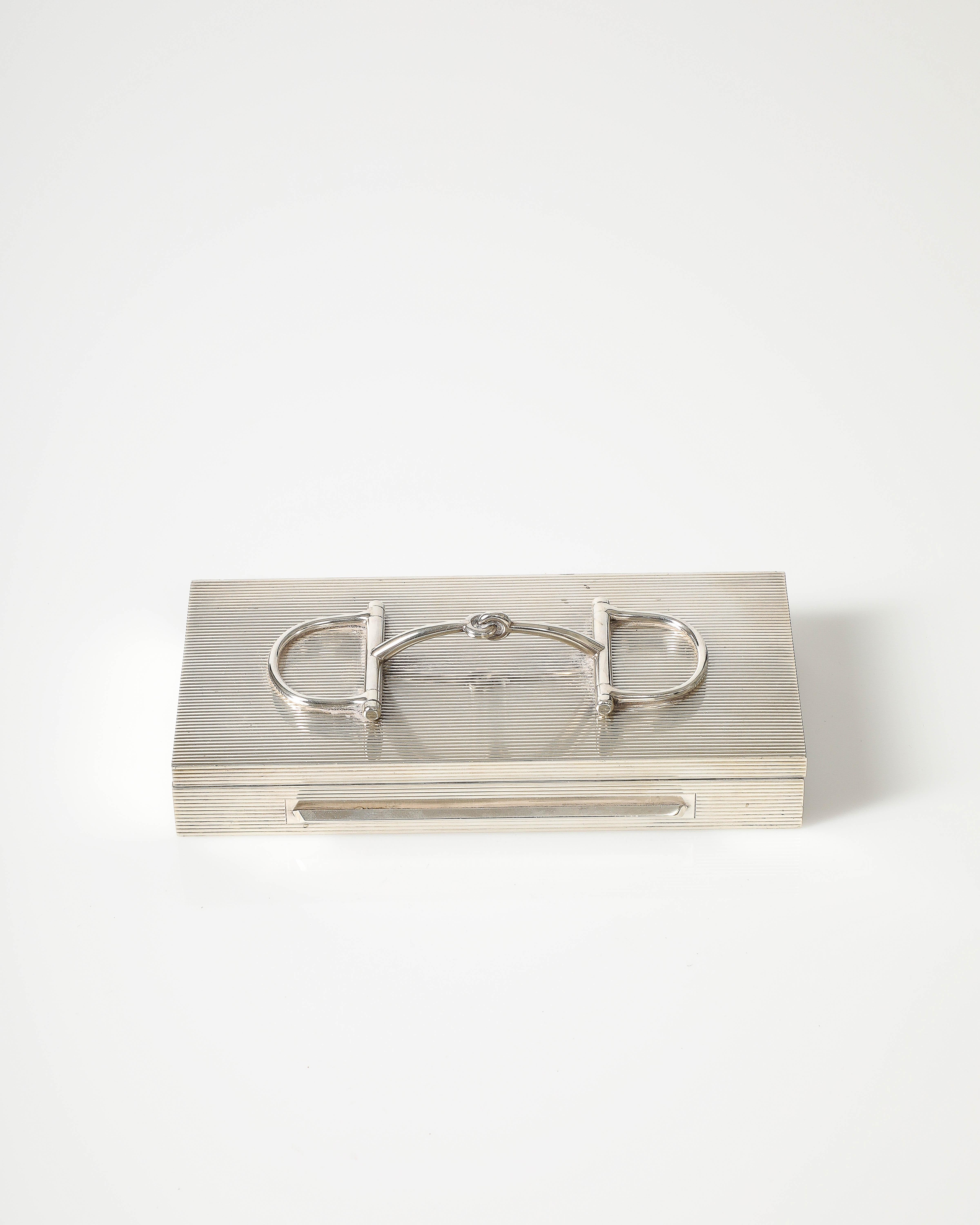 Elegante caja de metal con interior de caoba de Hermes, Francia, decorada con un emblemático bocado de caballo. 