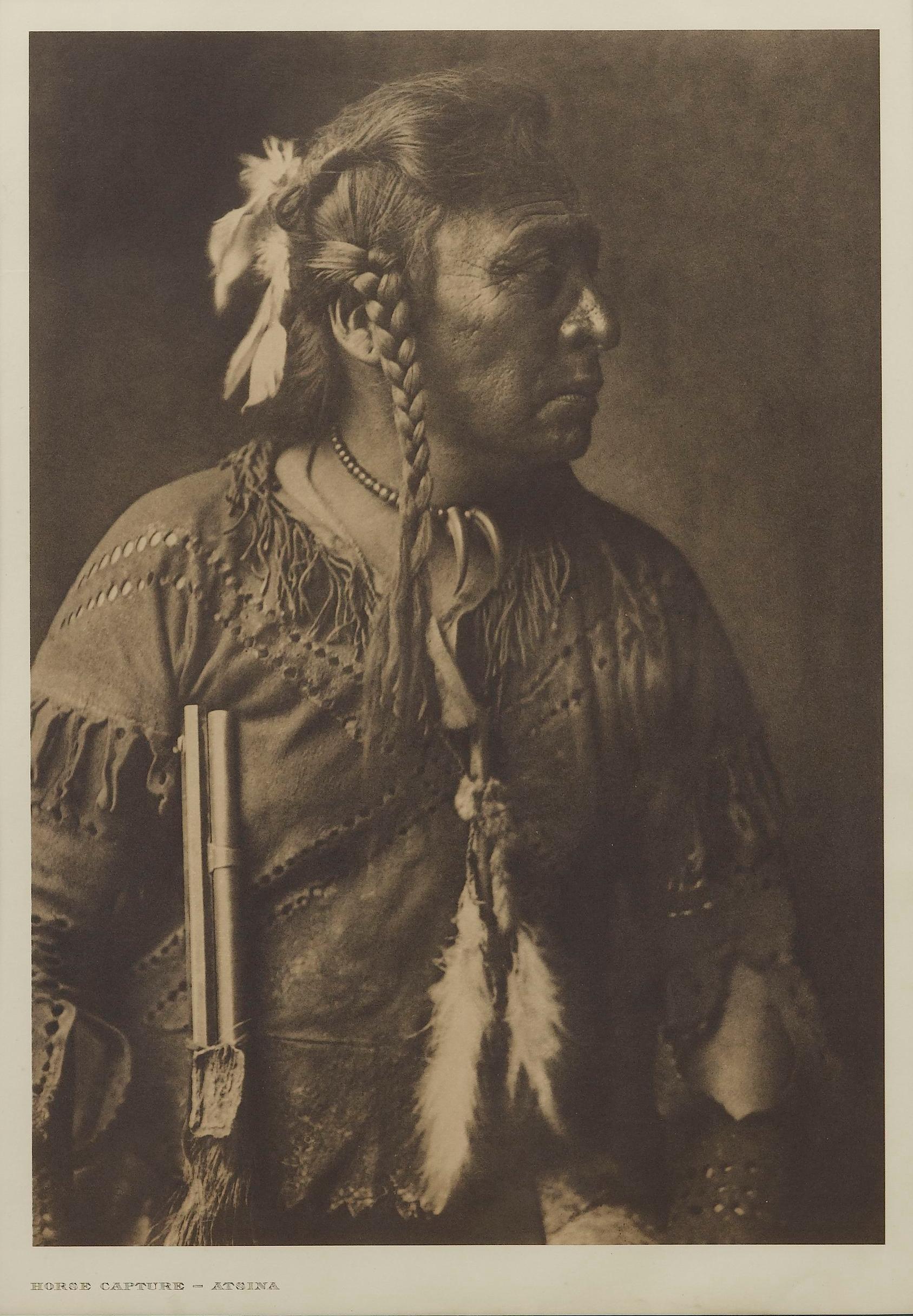 Presented is a fine photogravure portrait of an Atsina man named Horse Capture by Edward Curtis. The image is Plate 170 from Supplementary Portfolio 5 of Edward Curtis' epic project The North American Indian. The photogravure was published in 1908