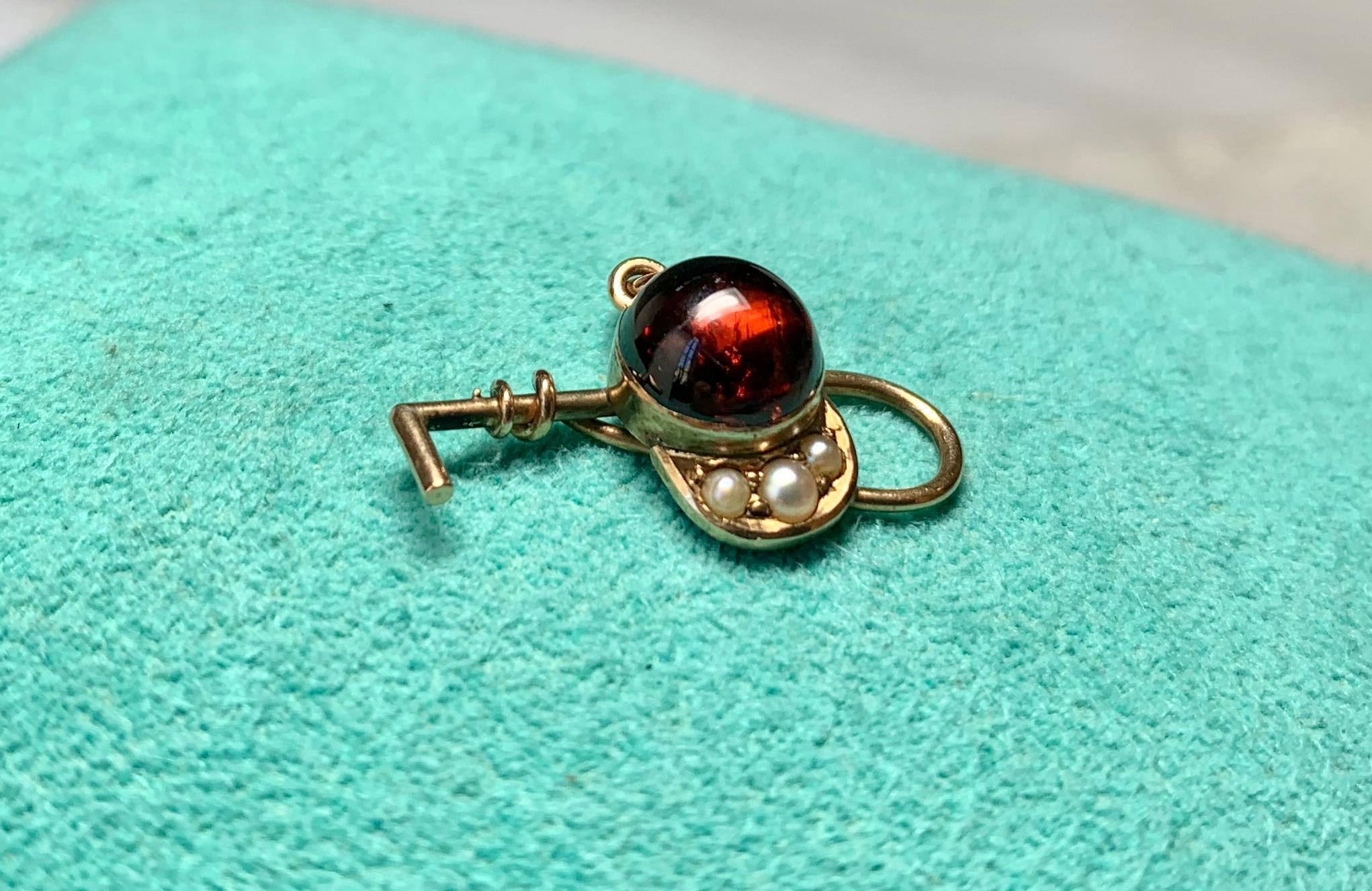 THIS IS A WONDERFUL VICTORIAN - EDWARDIAN PENDANT OR CHARM IN THE FORM OF A RIDING HAT SET WITH A STUNNING ROUND NATURAL GARNET CABOCHON AND PEARLS, WITH A RIDING CROP!  THE PENDANT IN 14K GOLD DATING TO C1900.
What a wonderful piece for