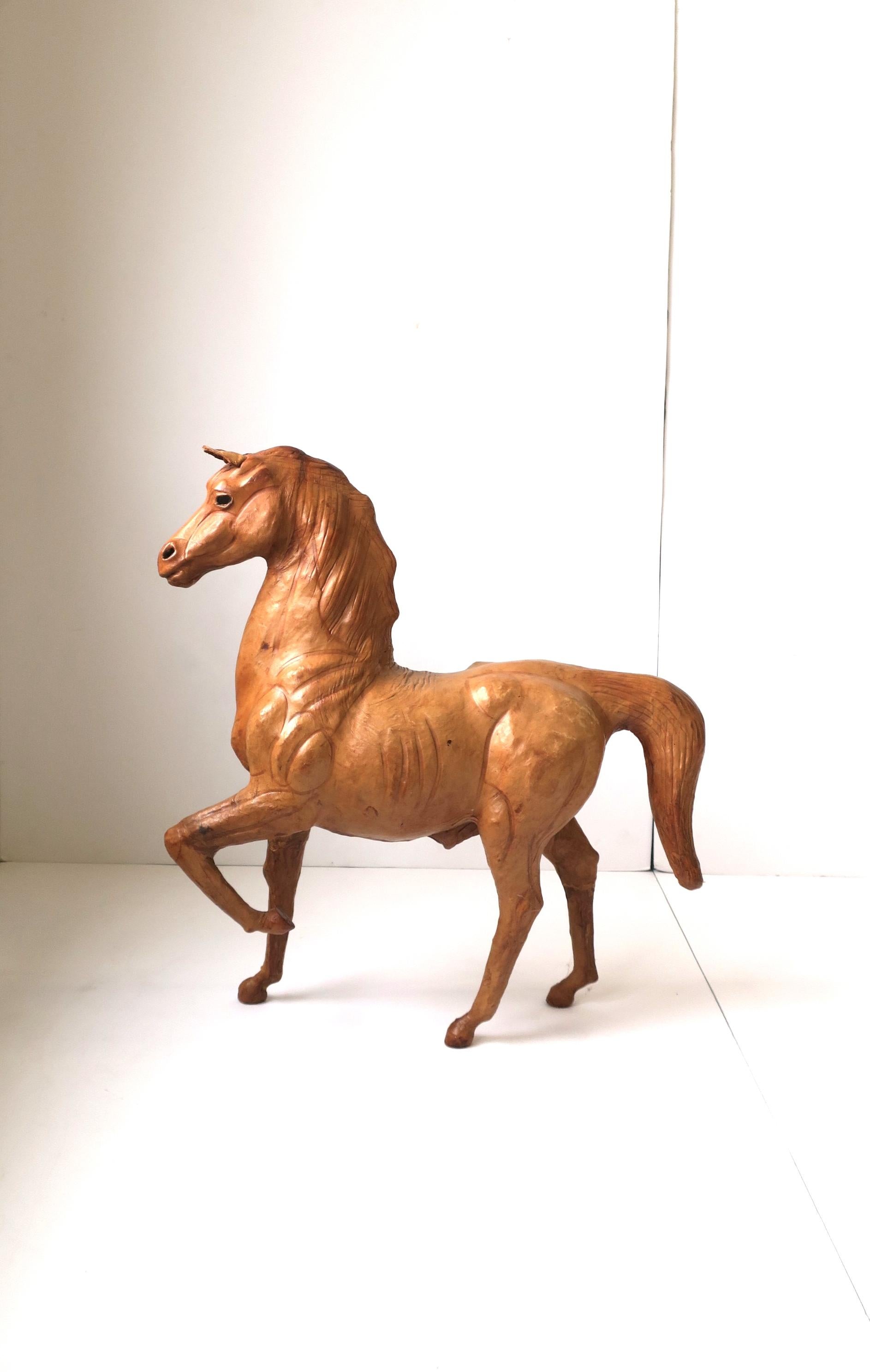 A beautiful all leather horse equine animal sculpture, circa late-20th century. This hand-crafted piece is clad in a light brown leather with glass eyes. For size perspective, please see image #8. A great decorative object sculpture piece. Piece is
