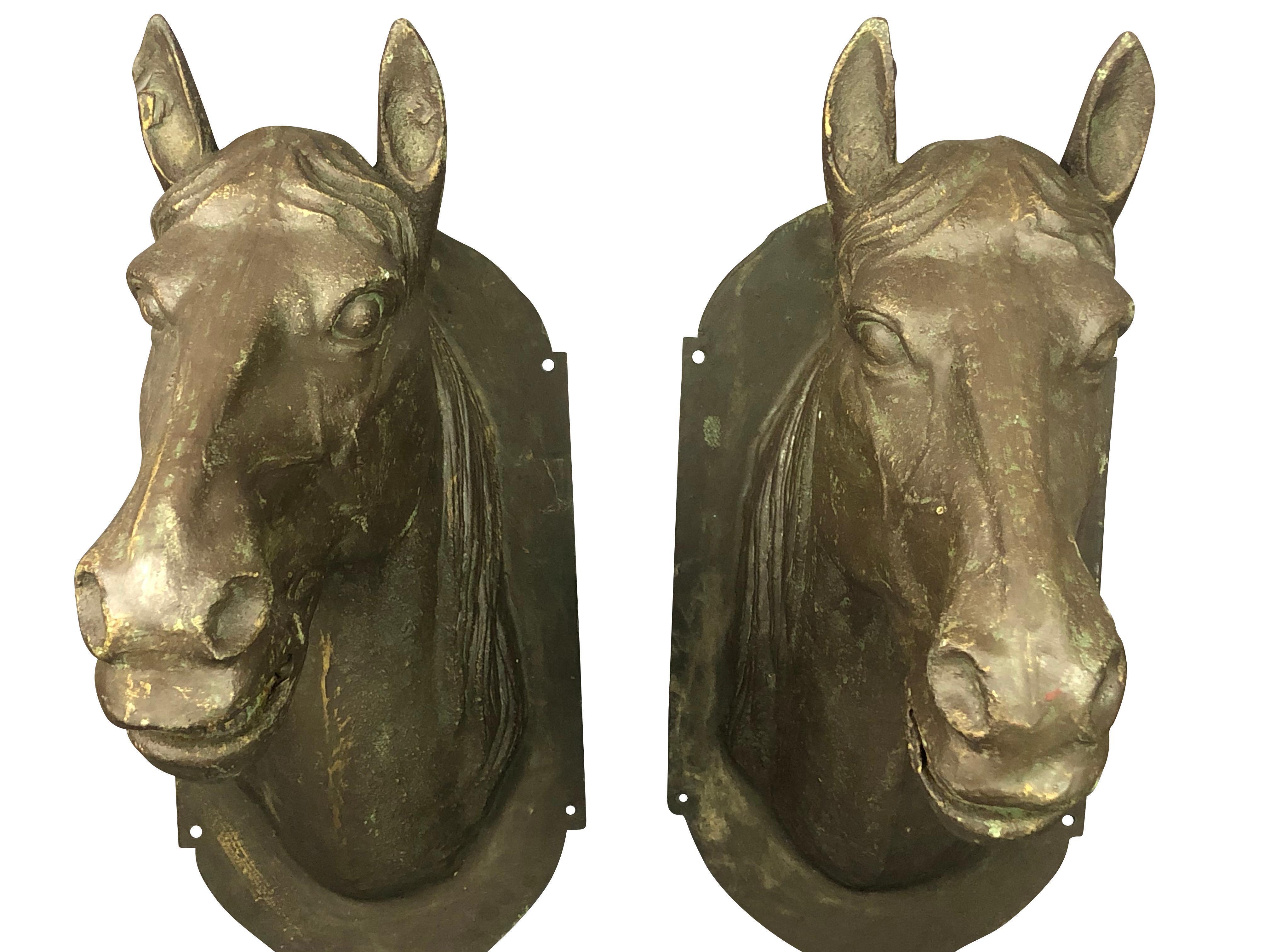 A pair of life-size metal horse heads that are beautifully rendered in mixed metal. Perfect to adorn a barn or doorway. Their coloration is a dark grey with a gold cast in strong daylight. Very realistic.