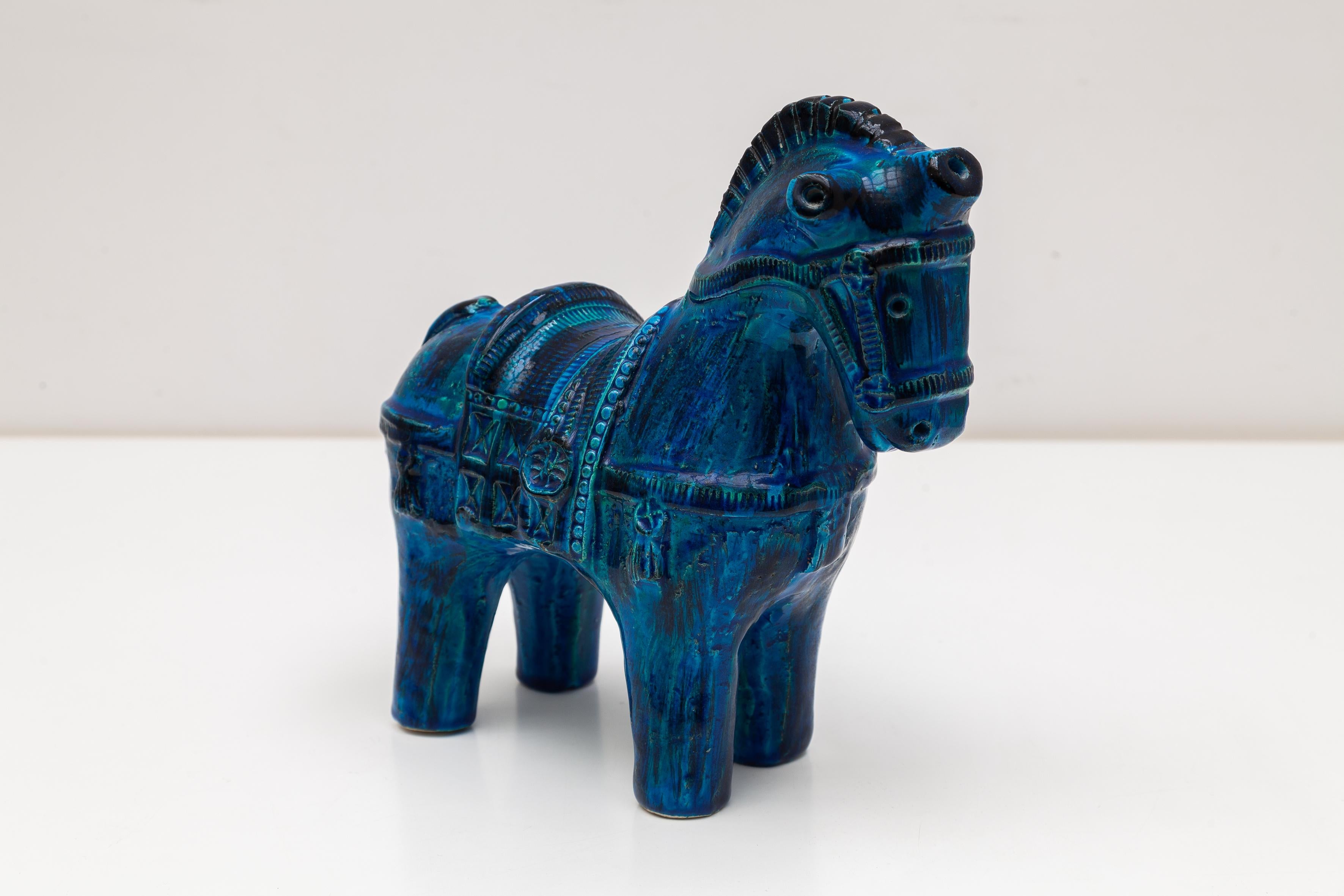 Blue ceramic statue of a horse with bridle and saddle from Aldo Londi. Bright blue-green glaze 