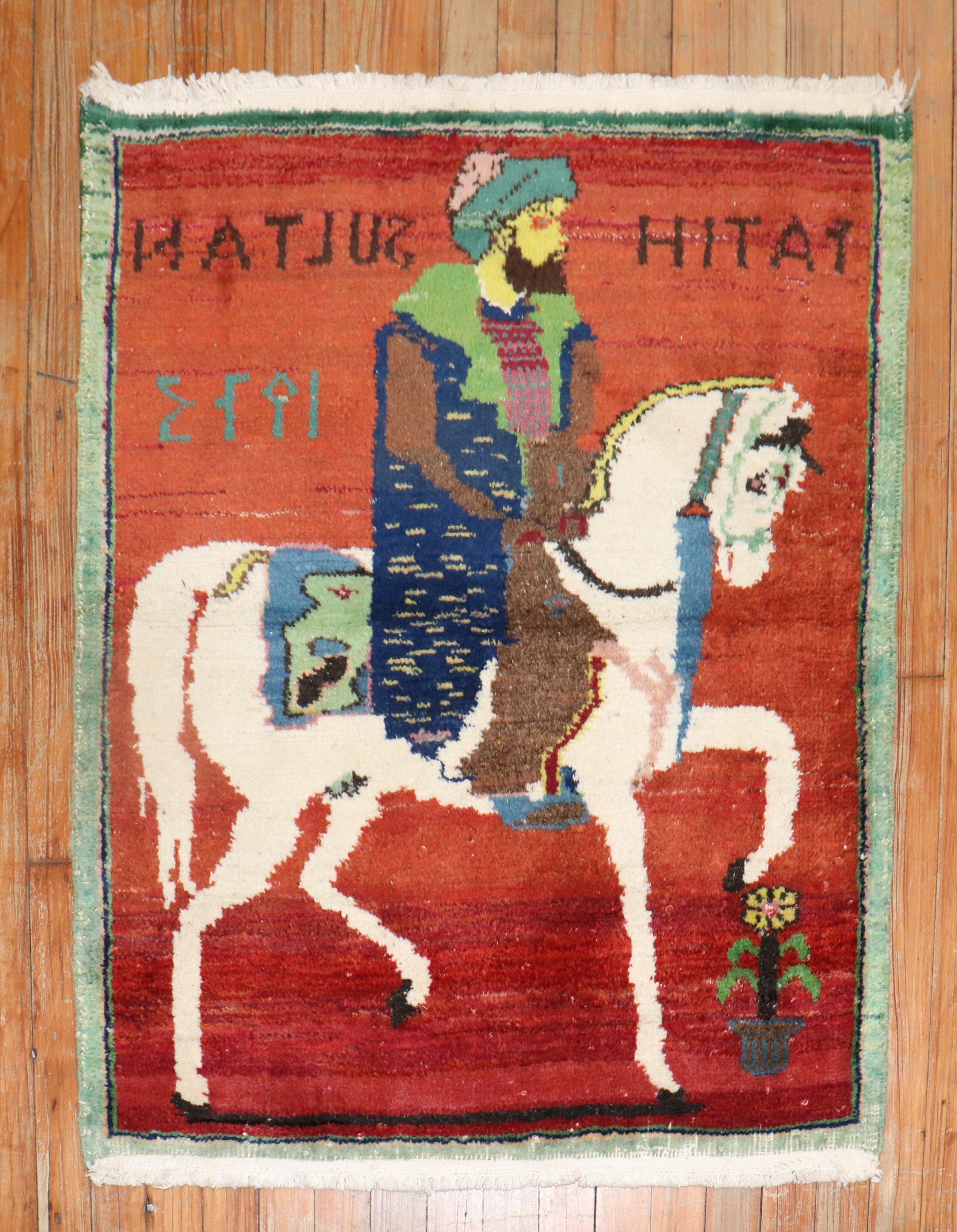 Vintage Turkish Pictorial Rug depicting a bearded gentleman riding on his horse on a red ground. dated 1973, the turkish names woven inscribed in seem to make it a dowry gift

Measures: 2'8'' x 3'2''.