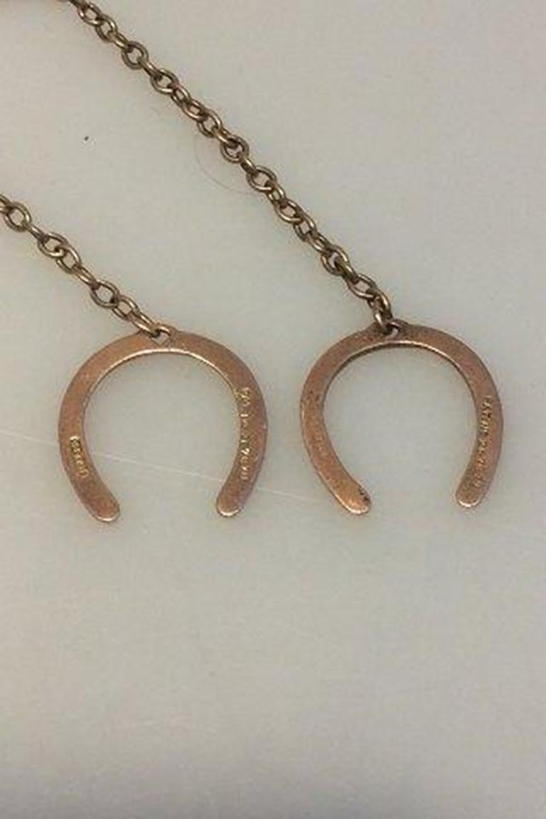 Horse Shoe pendant gold 14+ karat.

Measures 13.5 cm(5 5/16 in) Weight 7.3 gr/0.26 oz.