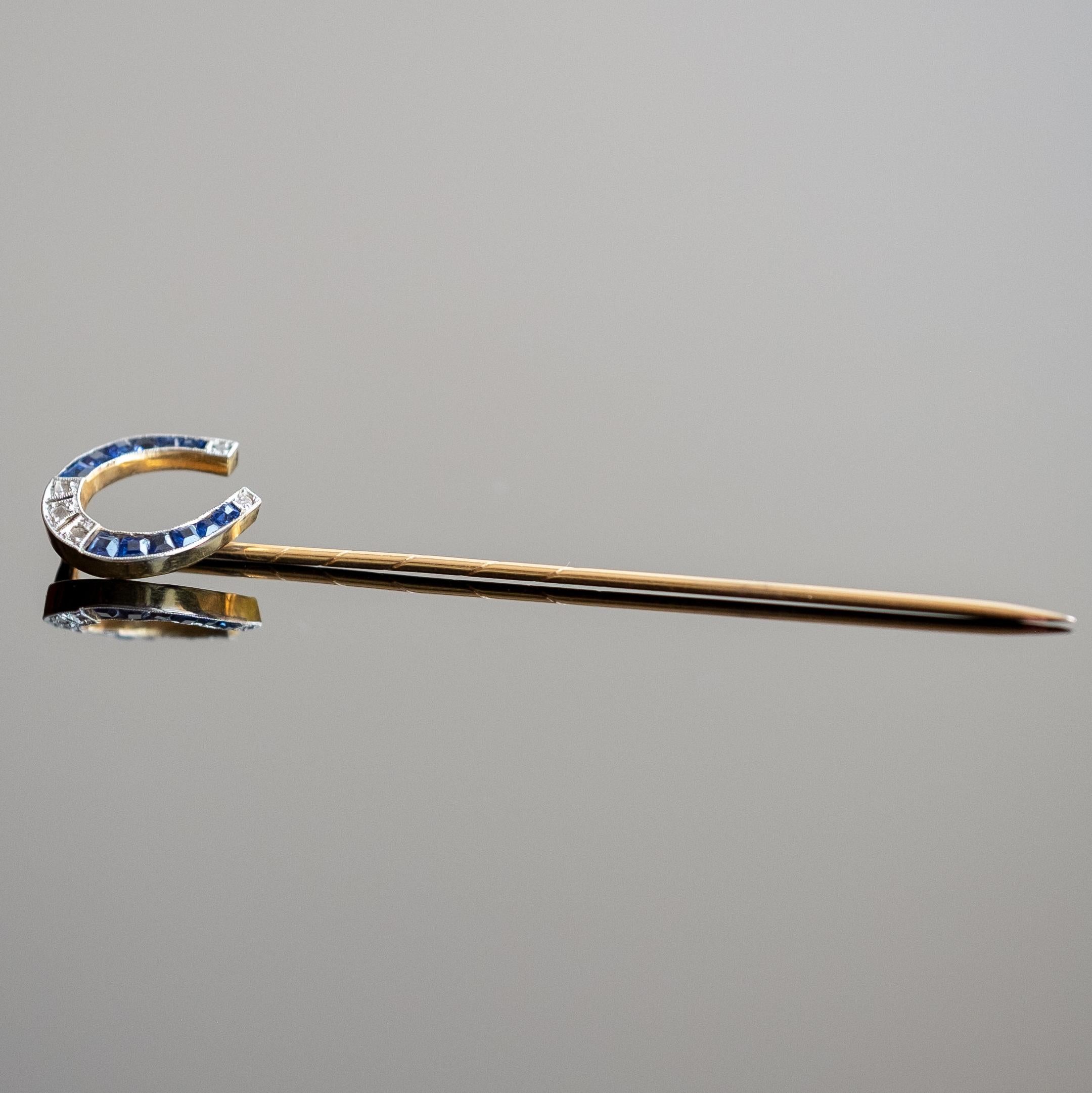 Stick pin set in 18ct gold with rose cut diamonds and calibrated sapphires. Deco period 1930s circa.

Highlights
- 18ct gold
- Rose cut diamonds
- Calibrated cut natural sapphires

Measurements
- Length 6.6cm x Width (at widest point) 1.2cm
- Weight