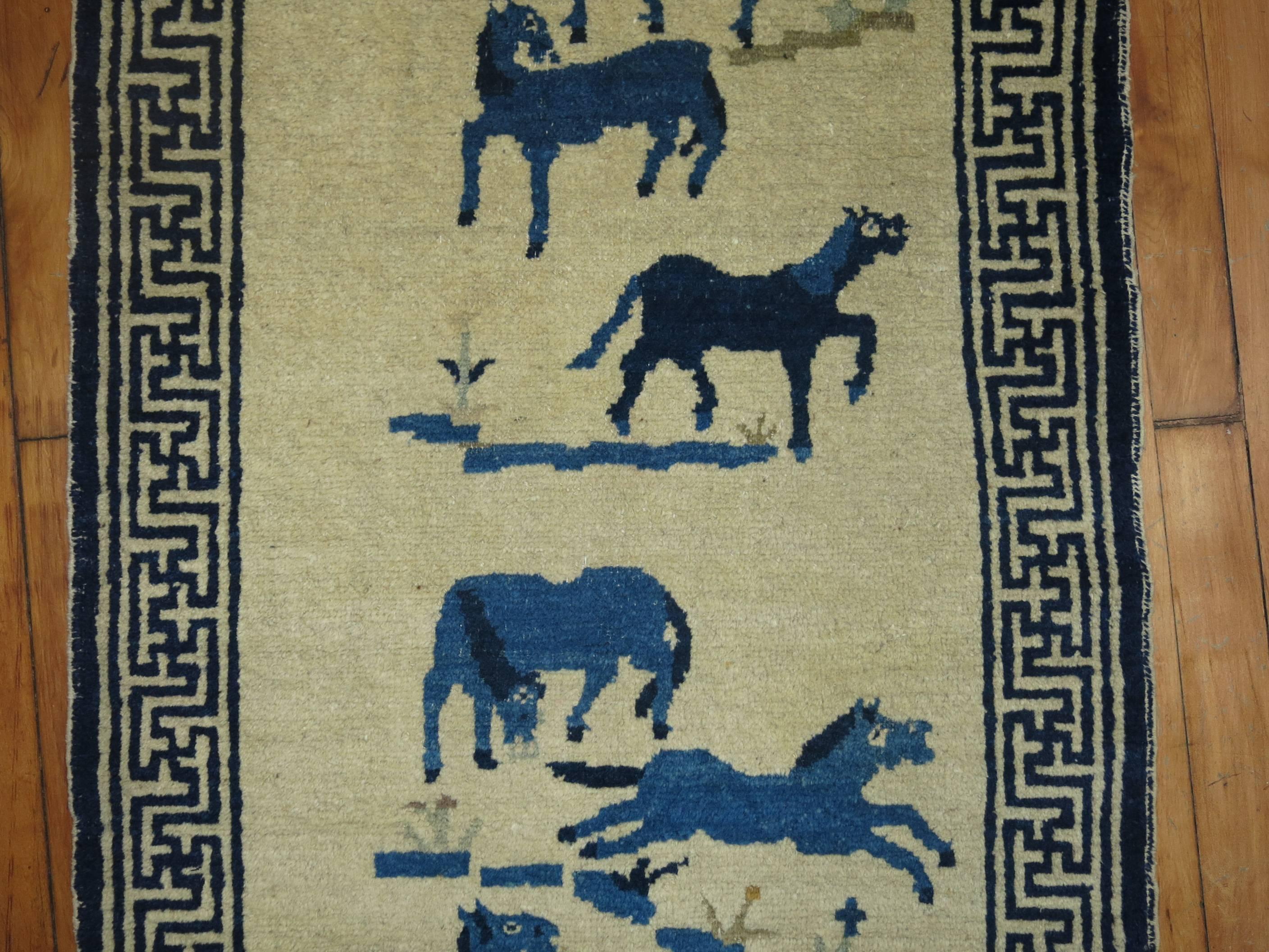 Un tapis chinois pictural pour chevaux du début du 20ème siècle. Six chevaux bleus flockés sur un fond de couleur ivoire.

2'2