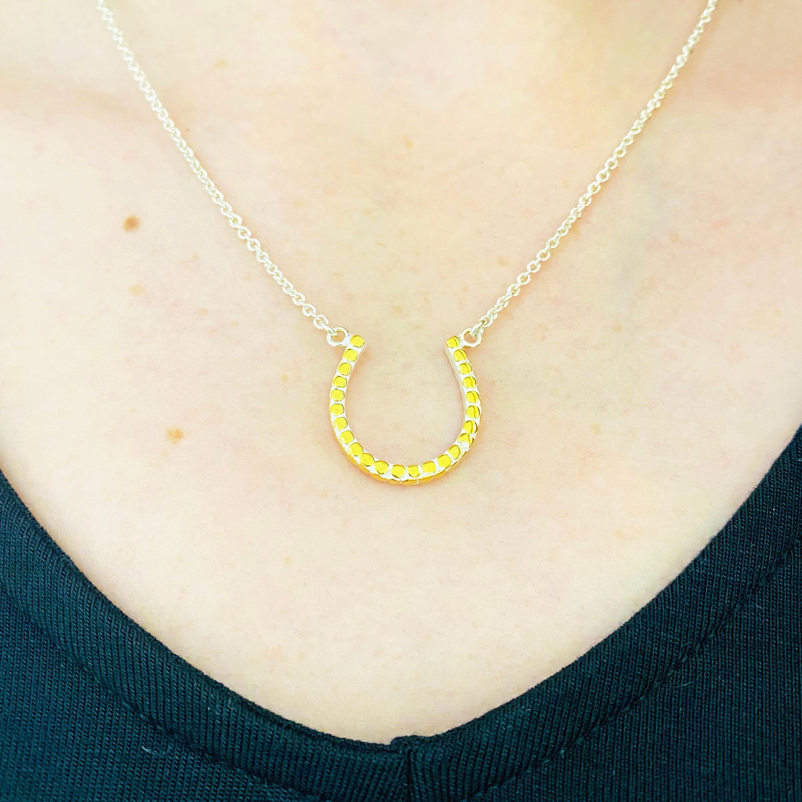 This gorgeous horseshoe pendant is a stunning and striking design. The horseshoe pendant is made in genuine 925 sterling silver and 18 karat yellow gold. The metal is a unique, anti-tarnish sterling silver. This pendant is on an 16 inch chain that