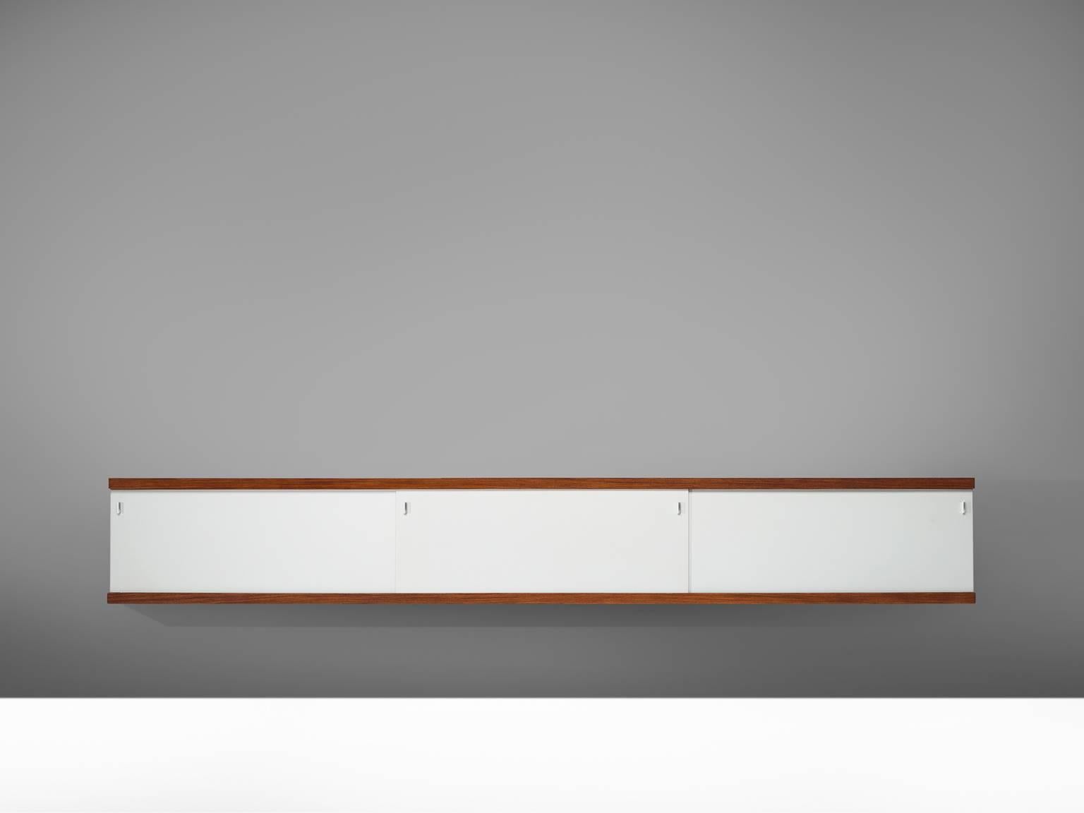 Horst Bruning for Behr, credenza, off-white grey plywood, rosewood, metal, Germany, 1960.

This simplistic geometric credenza holds a rosewood frame and a brushed metal frame. The sliding doors are made of white to grey Formica and have geometric