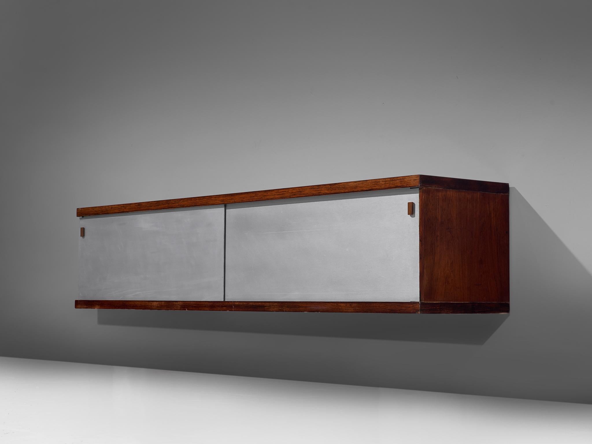 Horst Brüning for Behr, wall-mounted credenza, rosewood, aluminum and wood, Germany, 1960.

This simplistic geometric credenza holds a rosewood case and a brushed metal frame. The sliding doors are made of grey formica and have geometric grips.