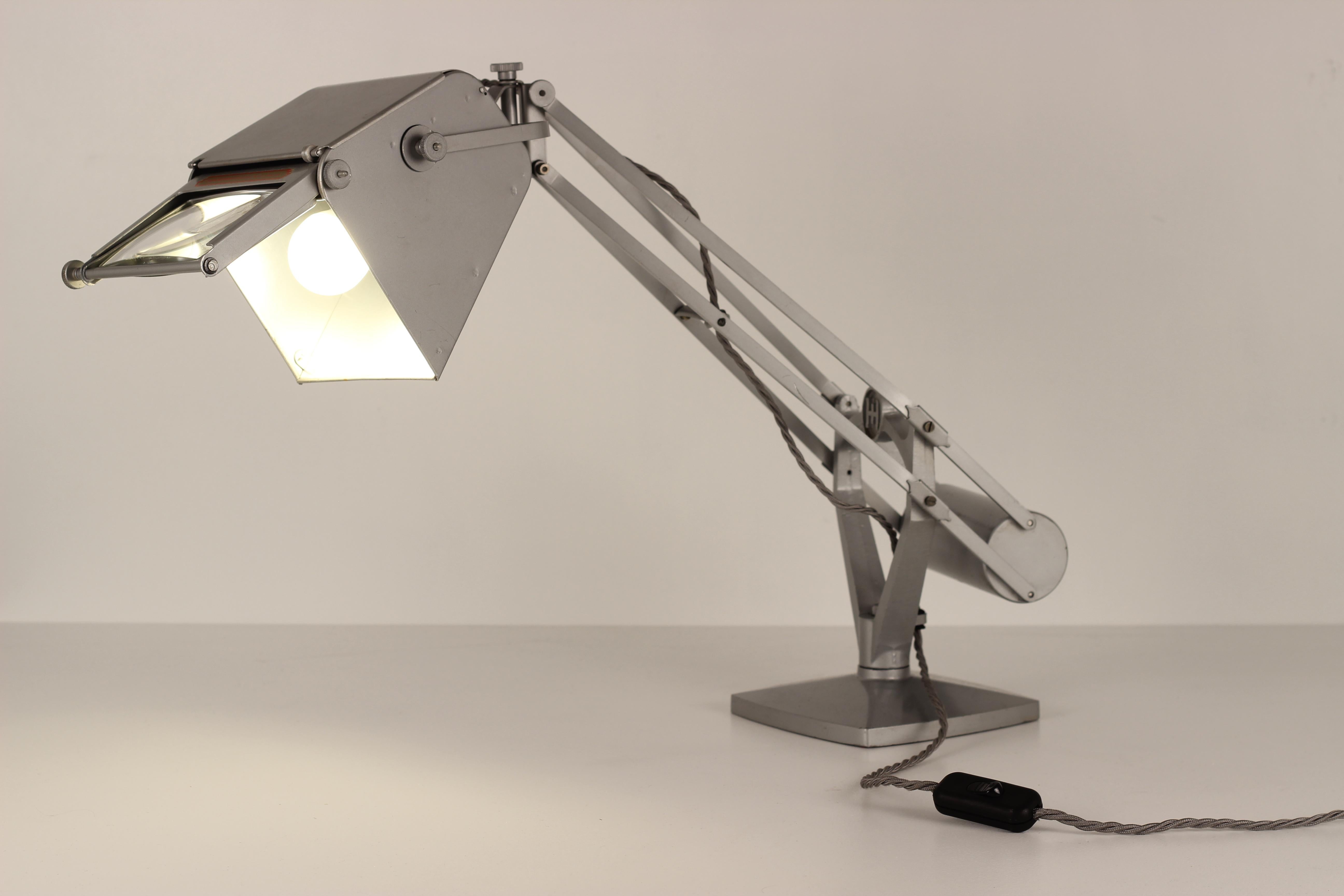 An original Horstmann magnifying anglepoise work lamp with weighted counterbalance. The Magnifying lens can retract to fit flush in the light head, which along with body will move in many different directions. This produces a work light that’s