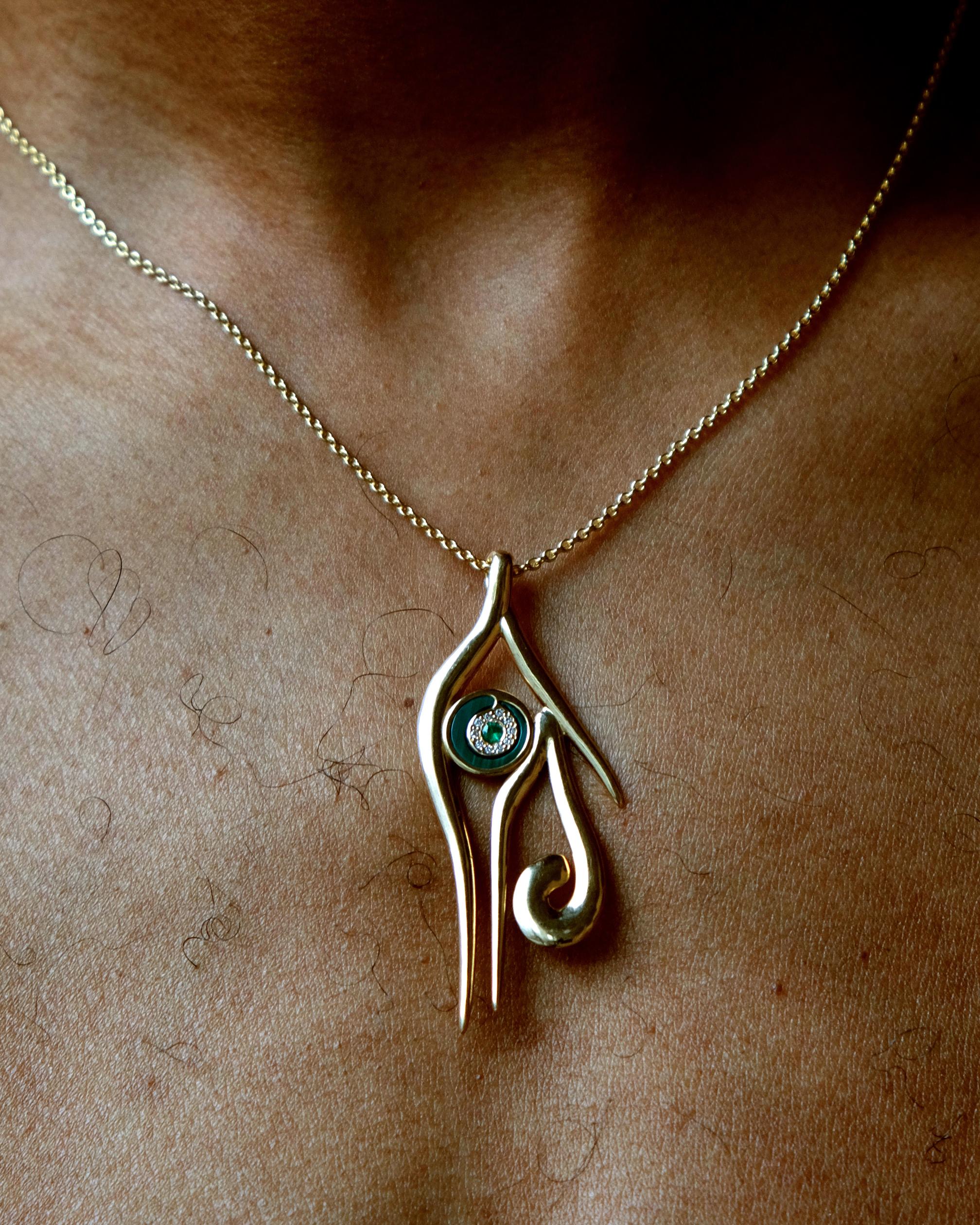 Pendant, depicting the Egyptian eye of Horus, a symbol of protection, royal power, and good health, rendered in solid 18k Gold set with emerald and white diamonds with hand-carved malachite inlay in KHIRY signature Khartoum Silhouette. 2 inch
