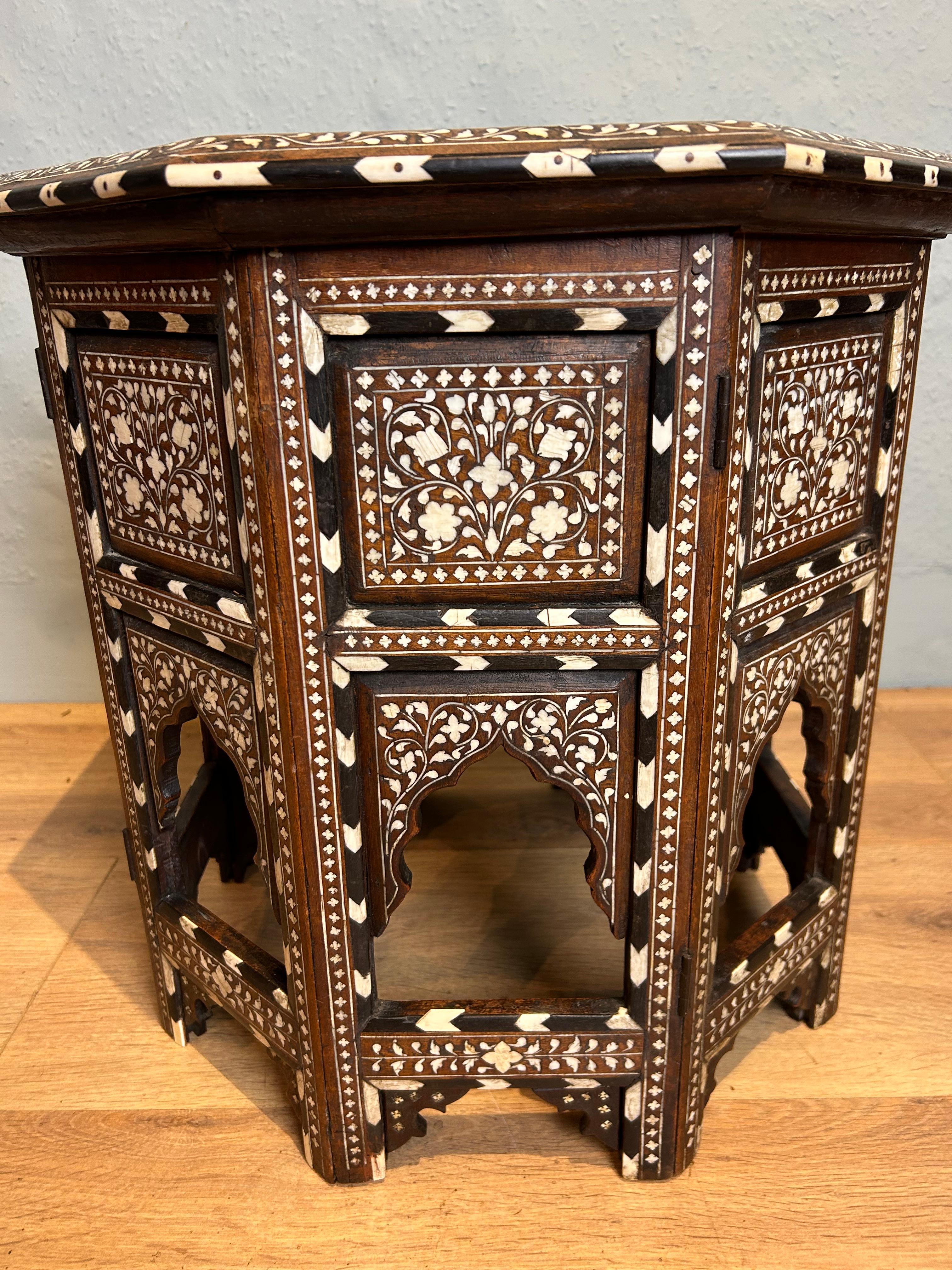 A rare and stunning profusely inlaid Hoshiapur octagonal table with barbers pole decoration to the top edge and side hinged panels. This fine quality table is lavishly inlaid to the top with Peacock, floral, folate, and quarter foil, designs. The