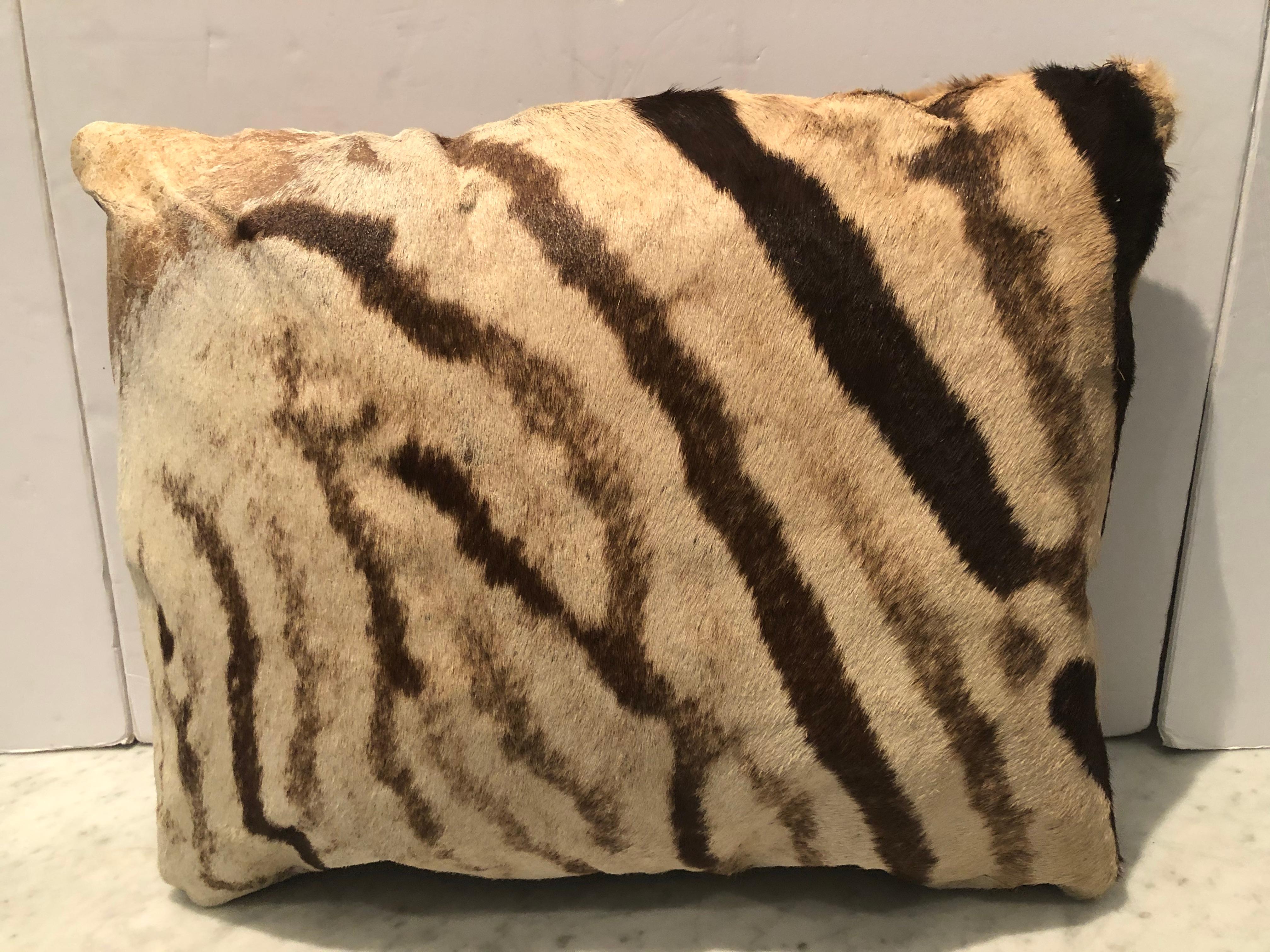 Pair of custom vintage burchell zebra hide pillows with brown leather backs. Pillows are handmade and filled with an insert of down and synthetics. Zipper closure. Measurements are 23” W x 10” D x 17” H and 20” W x 9” D x 15.5” H.
