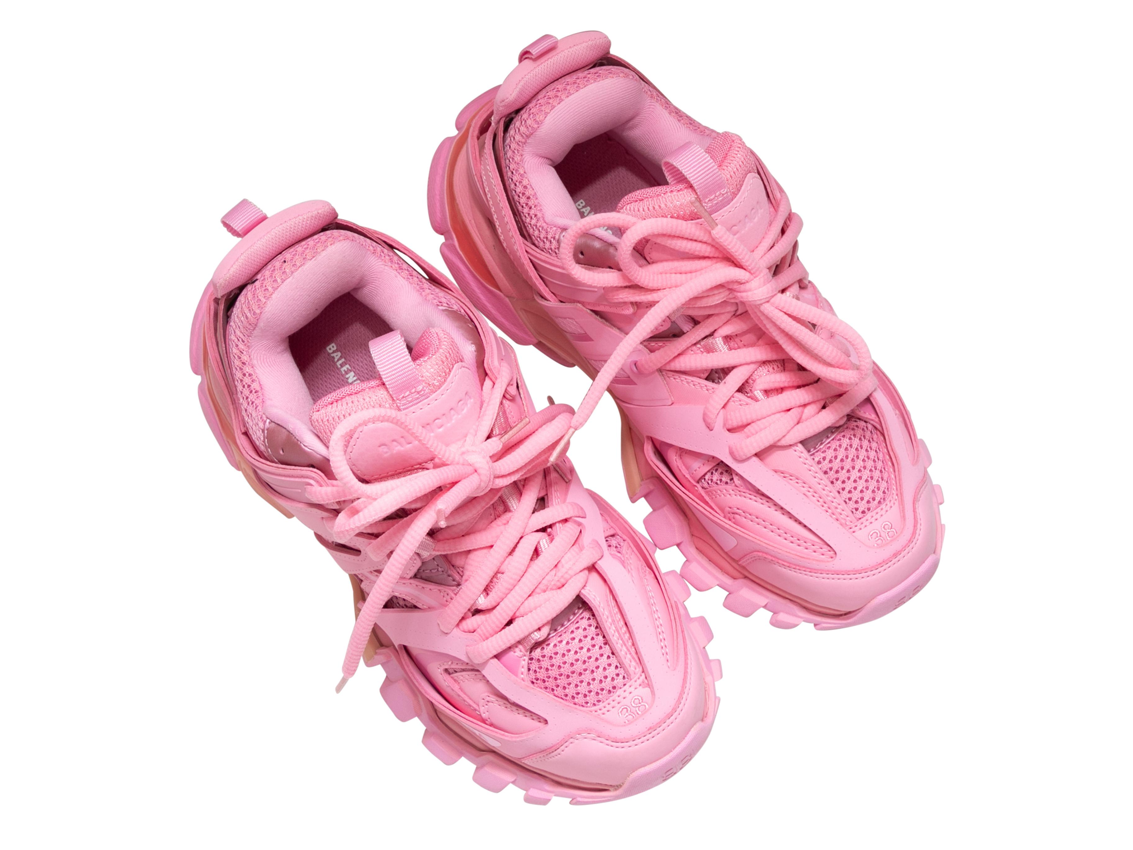 Product Details: Hot pink low-top Track sneakers by Balenciaga. Mesh detailing throughout. Foam rubber soles. Lace-up tie closures at tops. 1