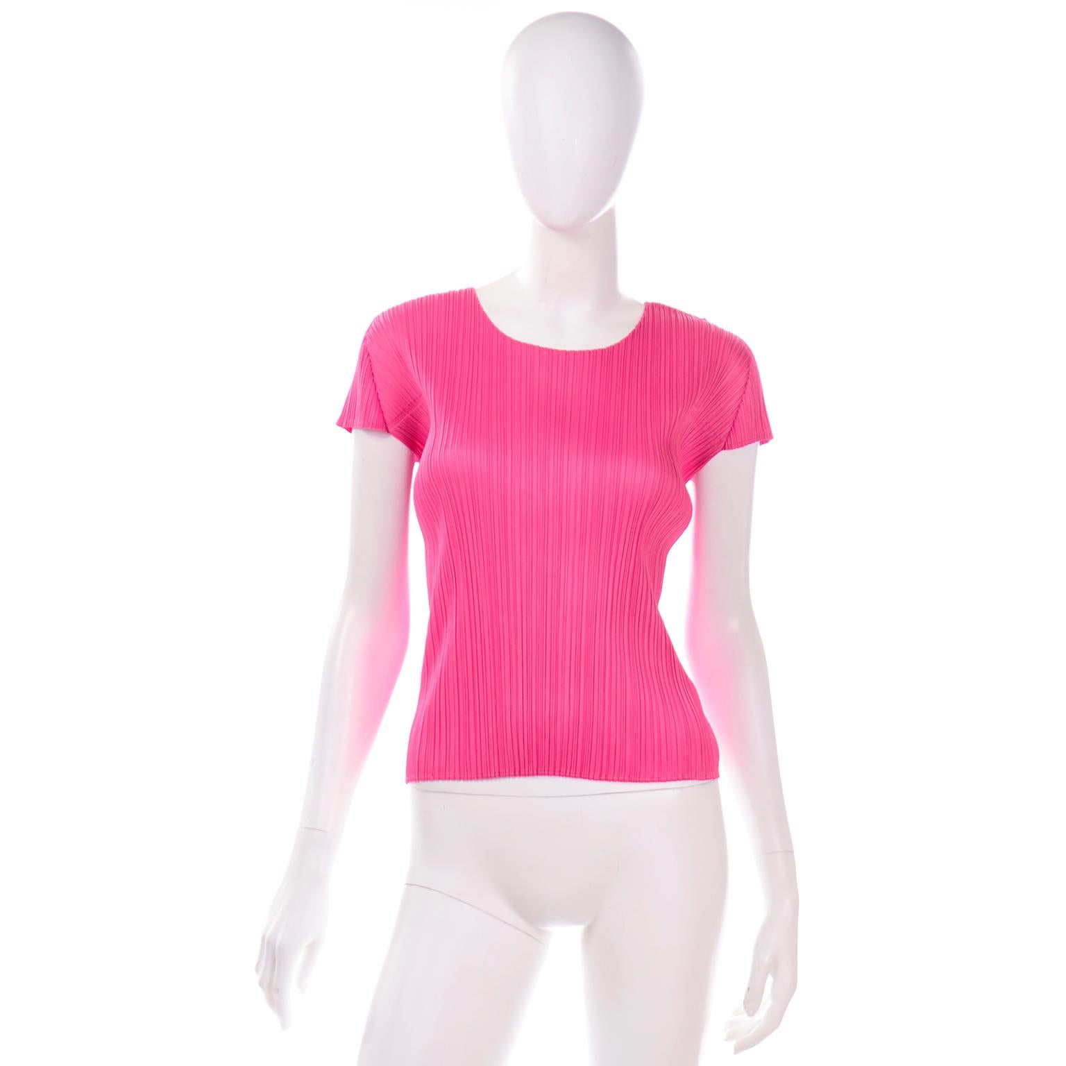 Si tratta di un top con maniche a pieghe di colore rosa acceso disegnato da Issey Miyake per l'etichetta Pleats Please. Questo top ha una vestibilità dritta e una scollatura rotonda. L'esclusiva plissettatura è una firma dello stile e della tecnica