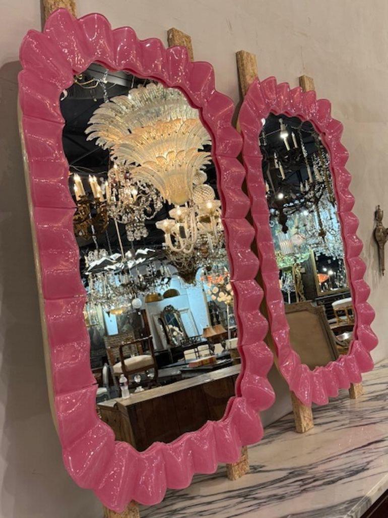 Questi audaci specchi in vetro di Murano rosa caldo sono un'elegante aggiunta all'arredamento di qualsiasi casa. Questi specchi unici sono realizzati in vetro di Murano di un vivace colore rosa caldo, per aggiungere un tocco di colore e di stile a
