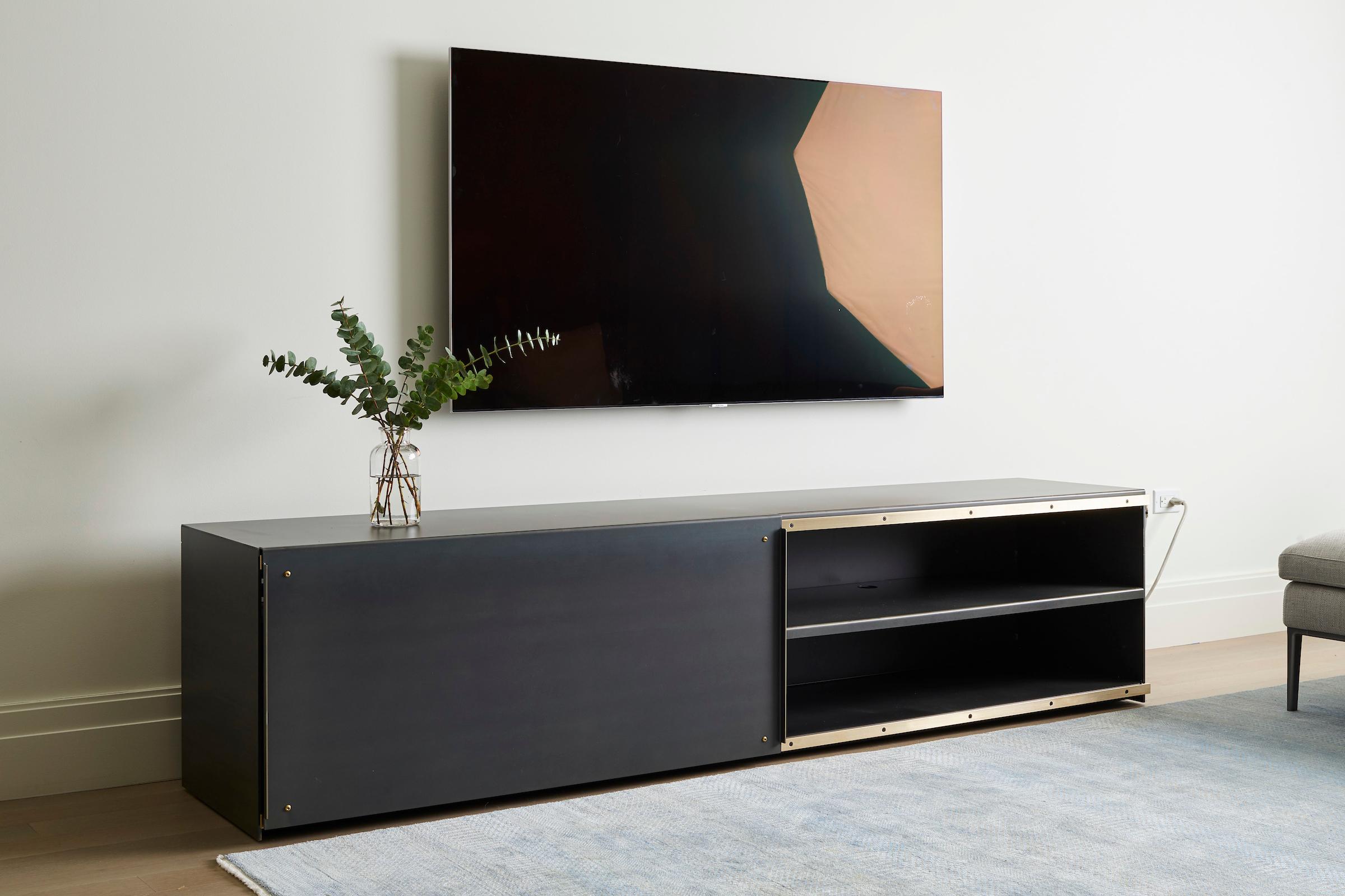 Il nostro pezzo inaugurale, il Media Cabinet, è realizzato in acciaio laminato a caldo e ottone Architectural Brass. L'interno è perforato per favorire il flusso d'aria e presenta perforazioni più grandi per la gestione dei cavi.