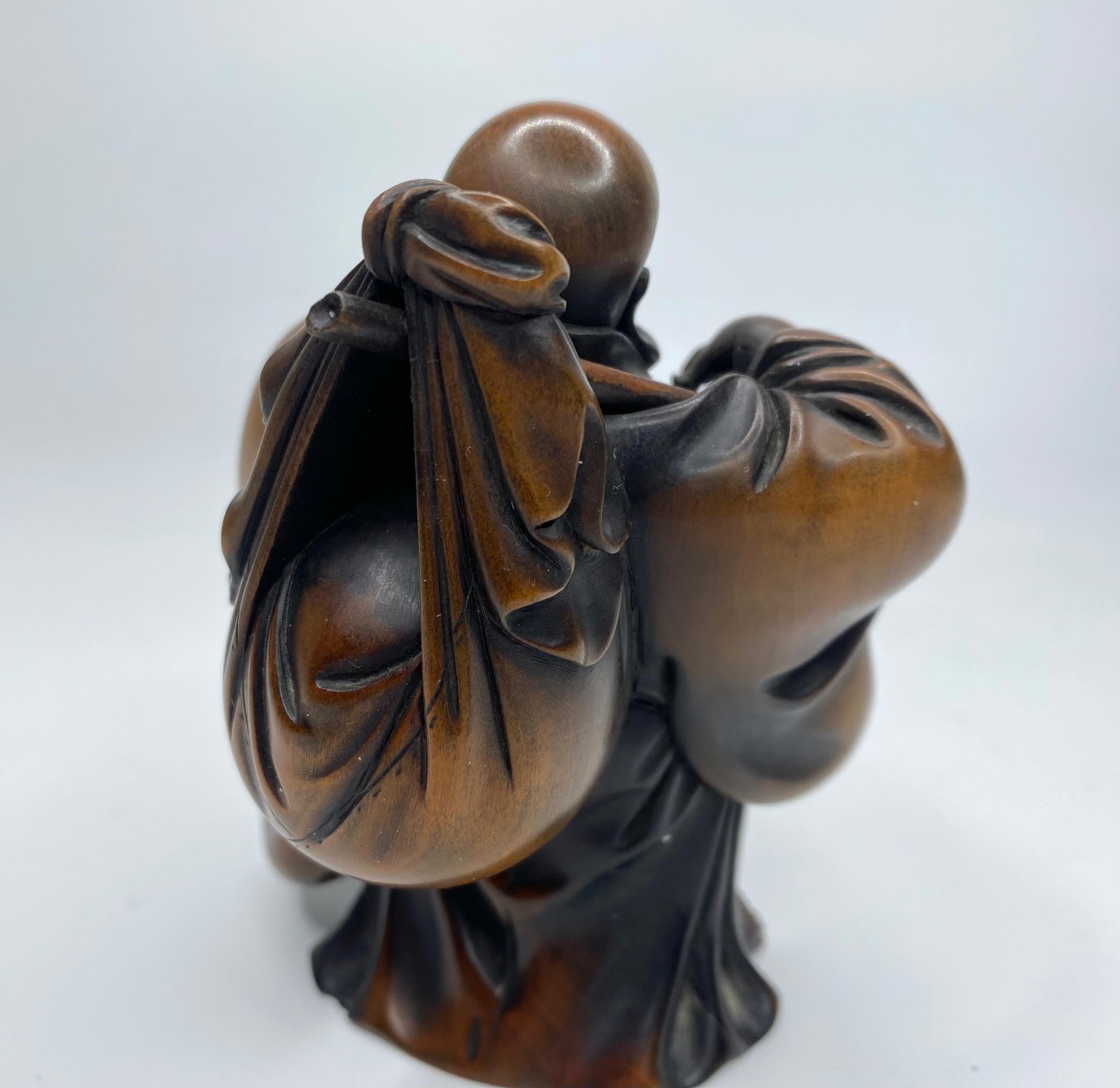 Hotei, a carved boxwood okimono, signed, Meiji Period. 3