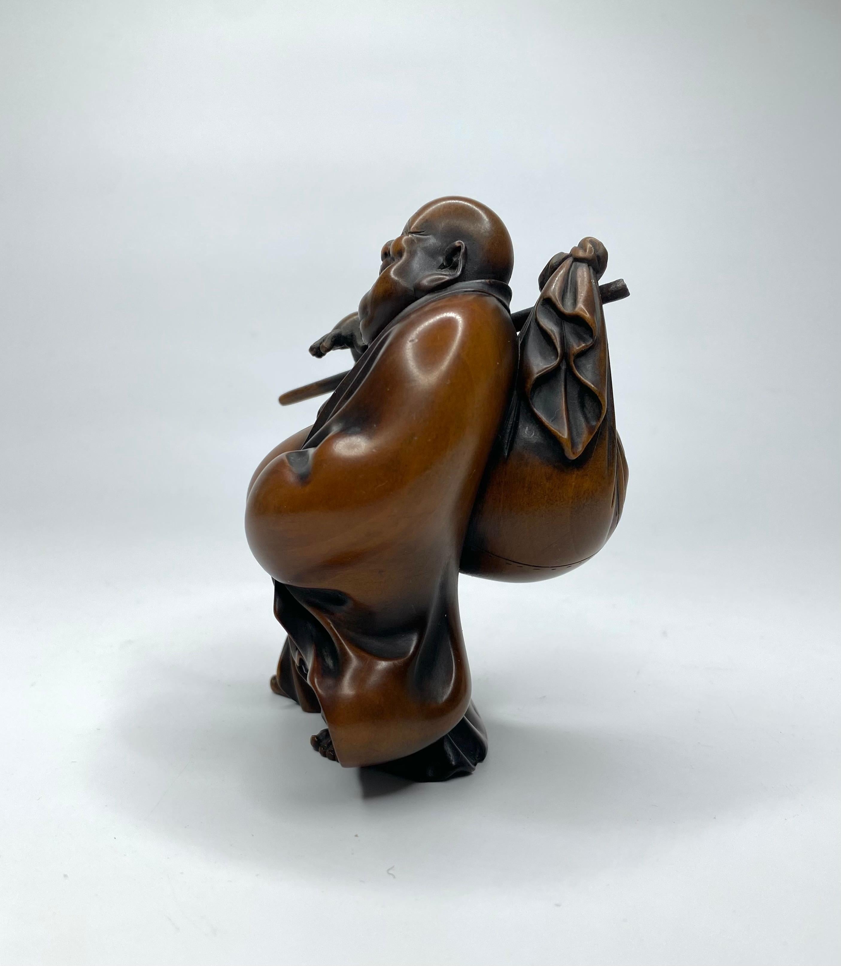 Japanese boxwood okimono of Hotei, signed, c. 1890, Meiji Period. Finely carved as Hotei, the Japanese God of good fortune and good luck, carrying his treasure sack. The figure is expressively carved, open mouthed, with a huge smile, bare breasted,