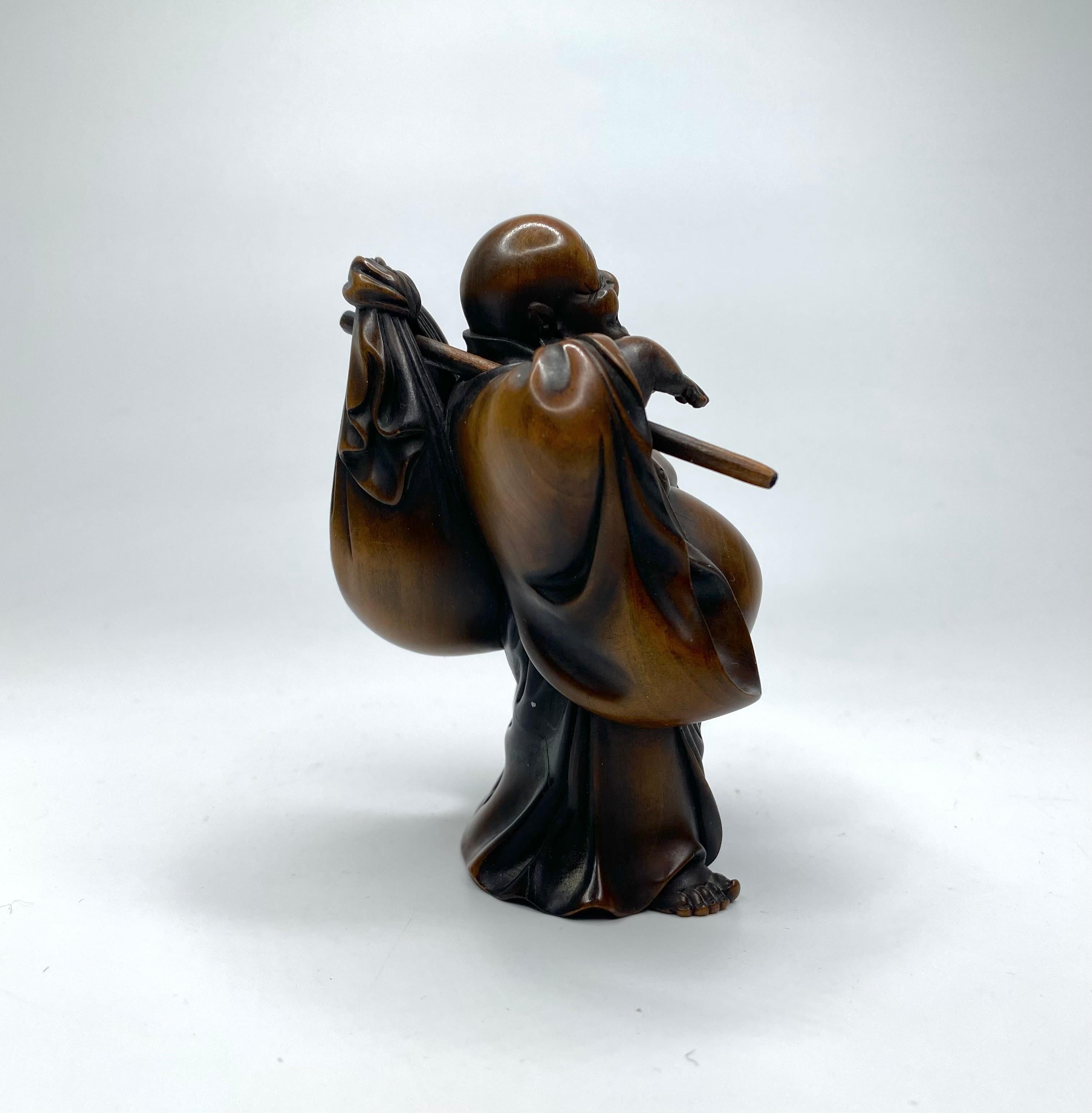 Carved Hotei, a carved boxwood okimono, signed, Meiji Period.