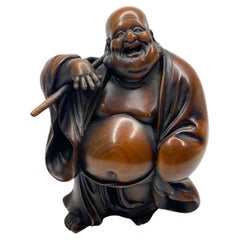 Hotei, a carved boxwood okimono, signed, Meiji Period.