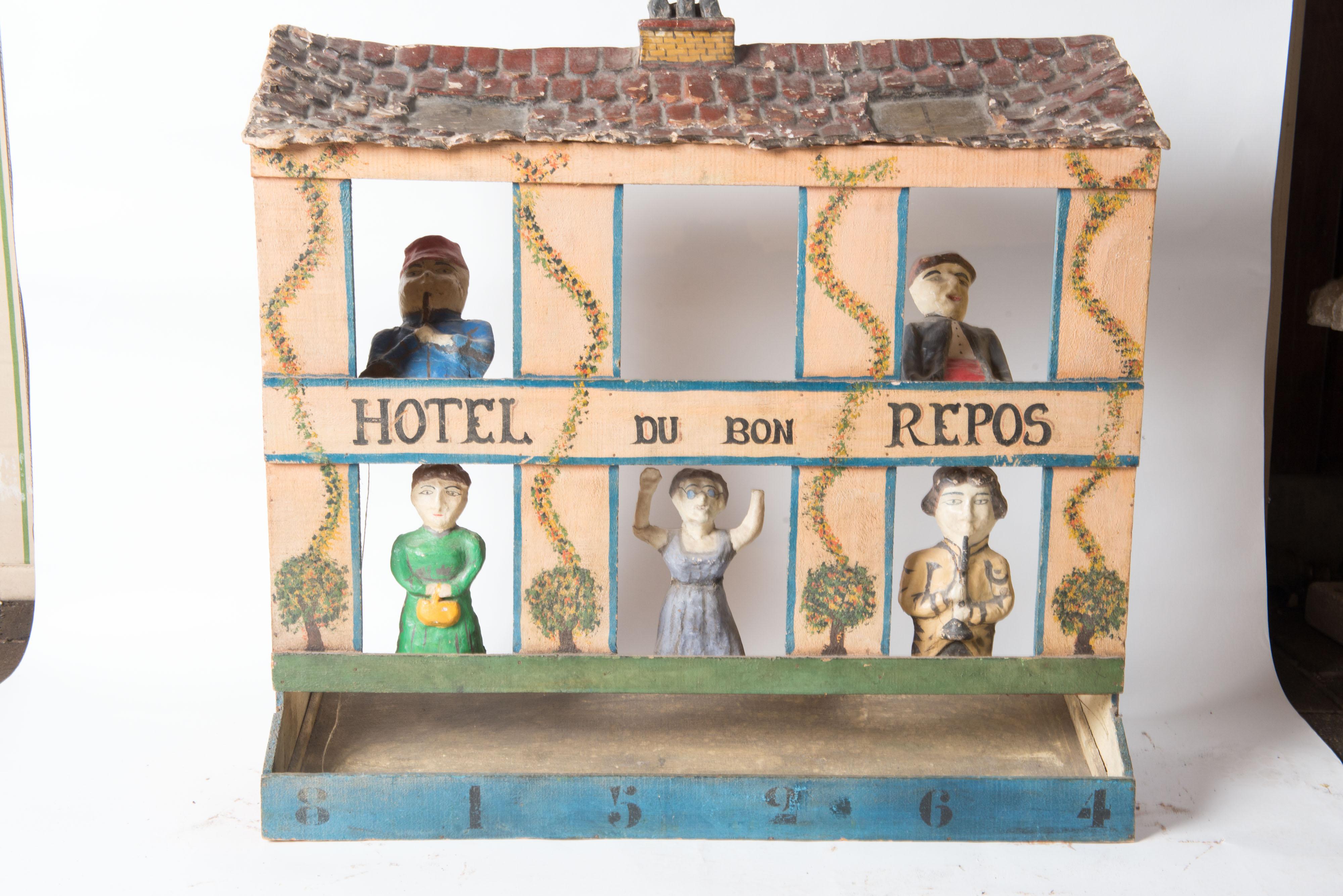 An old French game, hand painted wood and papier mache with five figure in the windows and a detailed papier mache 