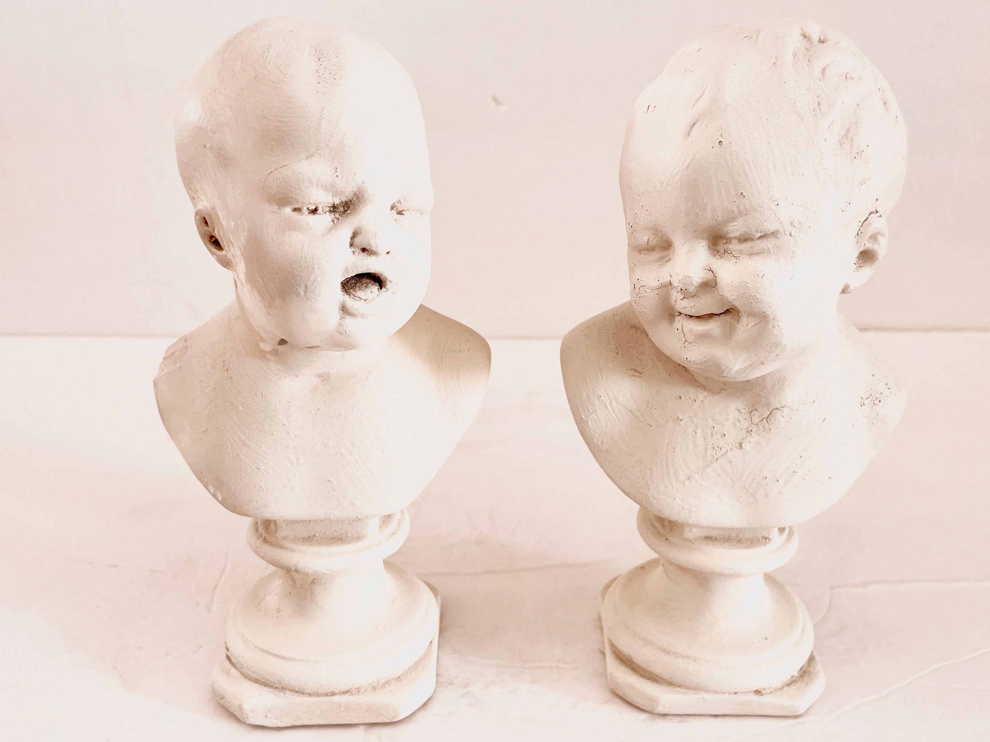 Mignonne paire de mini-bustes de bébés aux visages pleurant et riant par Houdin. Ils sont de petite taille et réalisés en plâtre. Il est très rare d'avoir la paire.