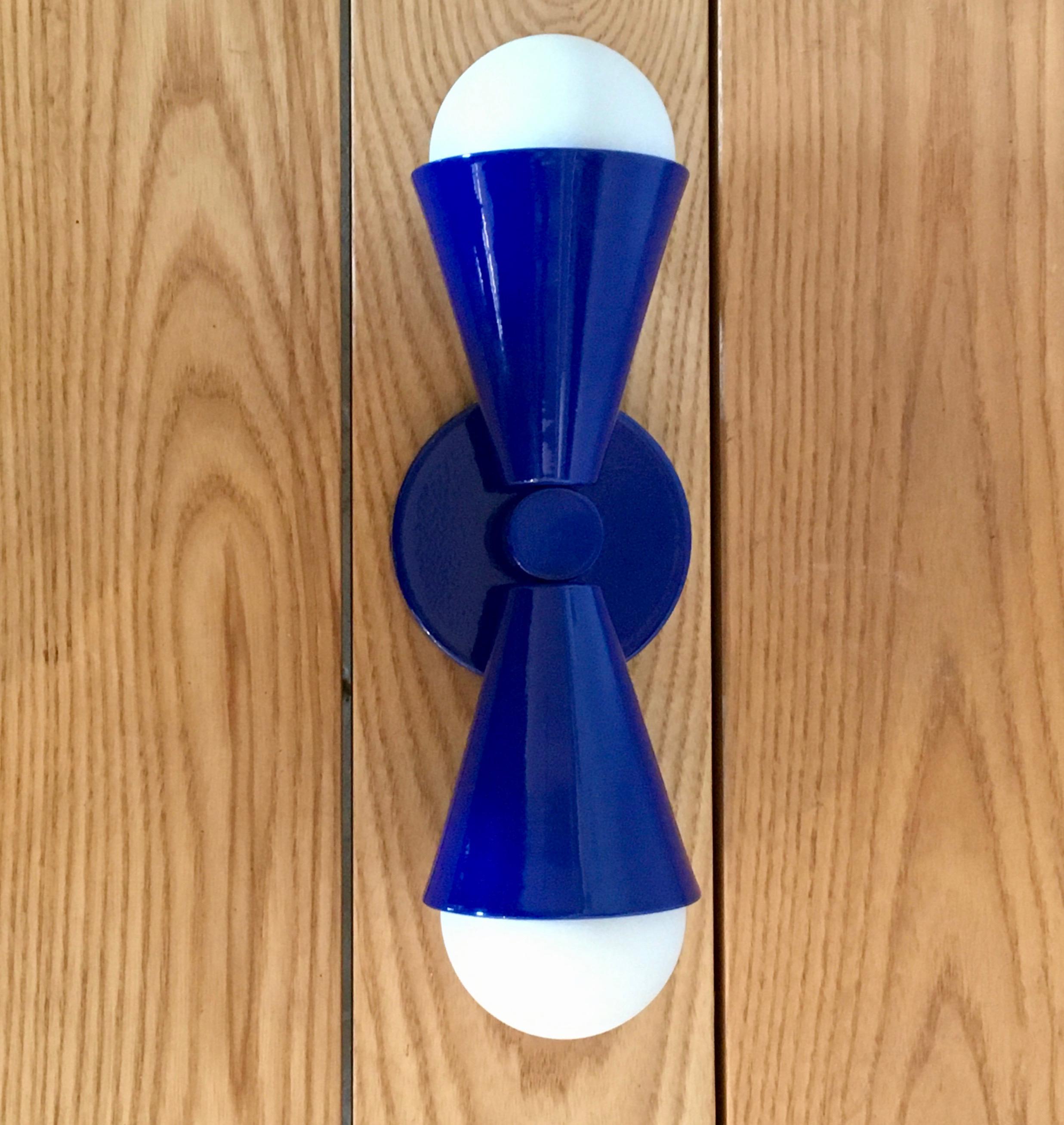 Geometric shapes and playful symmetry add up to our Hourglass sconce. Offered in three rich brass finishes or powder coated colors, this fixture is fitted with 2 E26 sockets, suitable for use with a wide variety of LED replacement bulbs. Main image