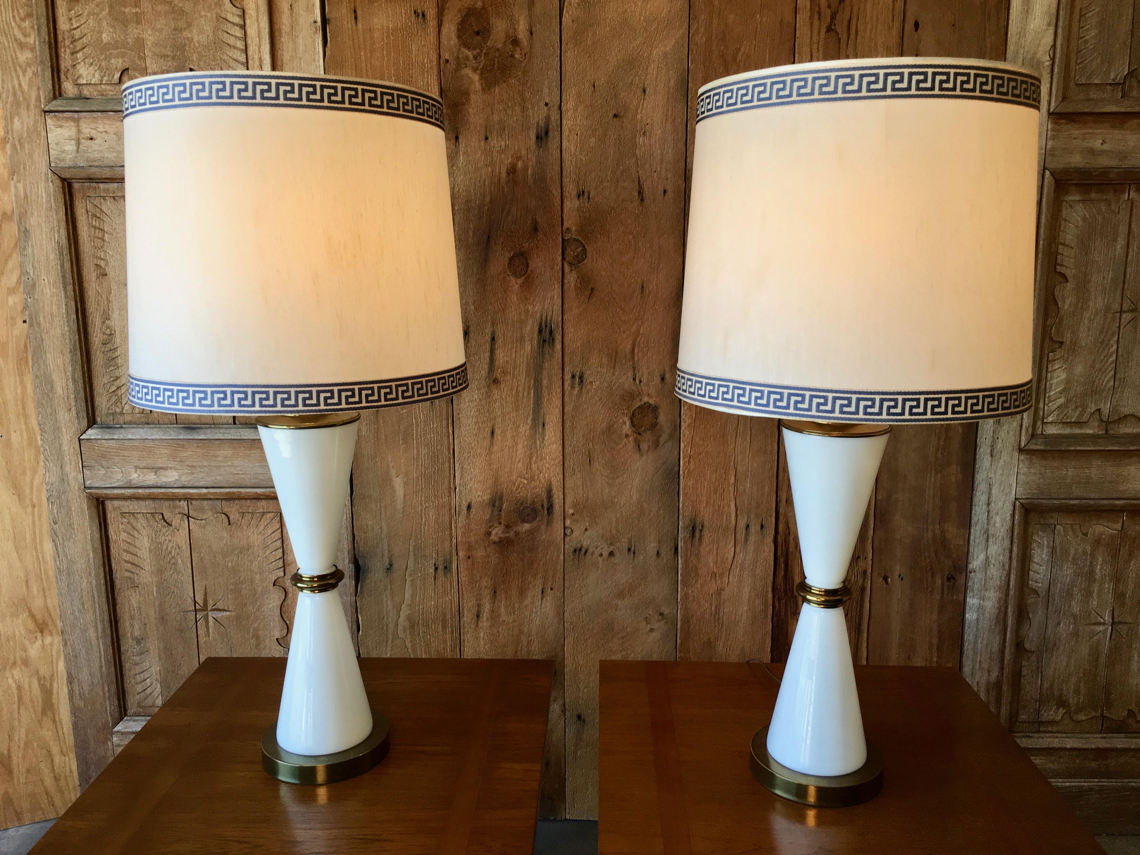 A pair of 1960s white milk glass with brass accents table lamps with Greek key lamp shades very nice quality the shades are 18