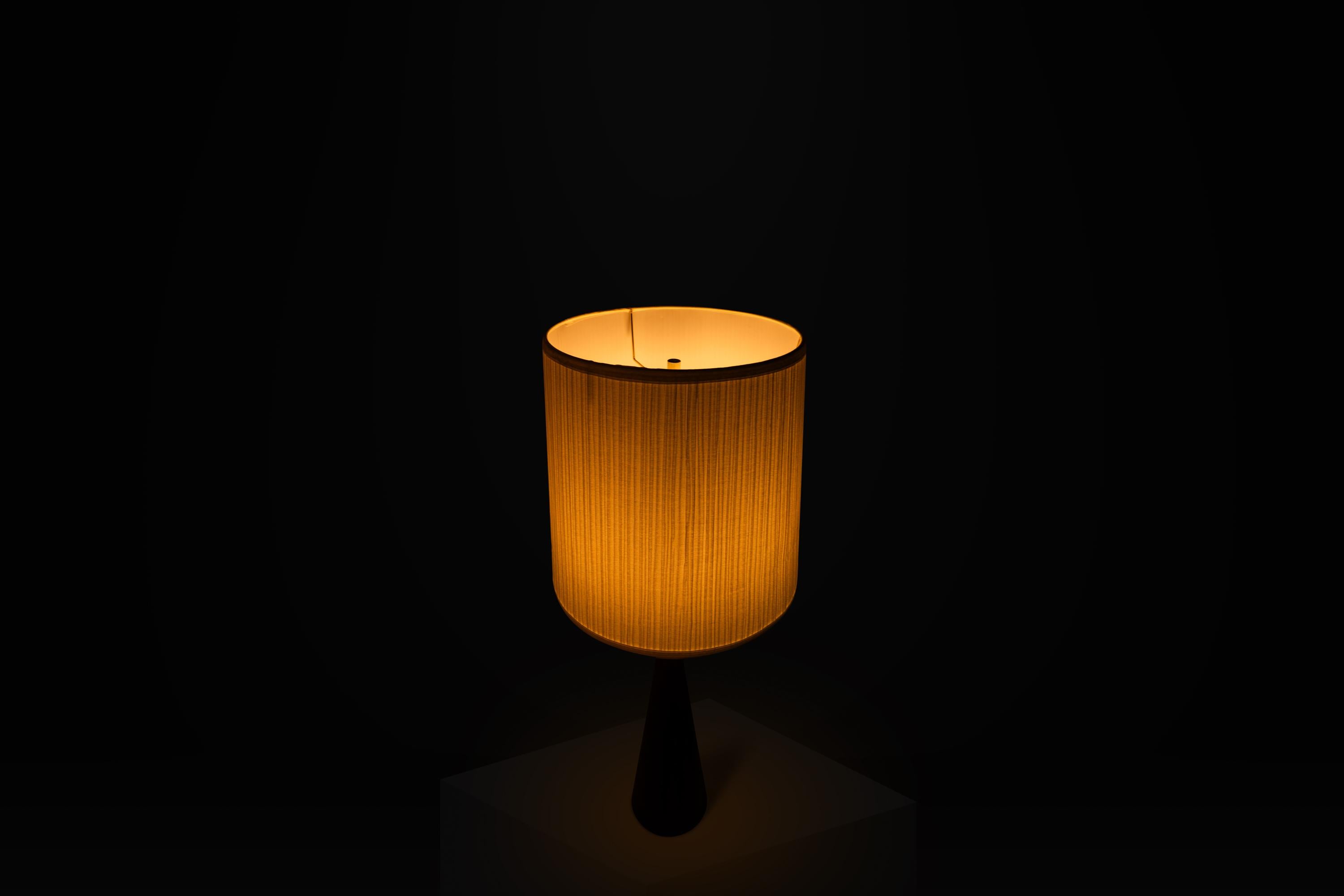Introducing an exquisite wood-turned, hourglass-shaped table lamp with a base made entirely from solid American black walnut. Attributed to the late great Phillip Lloyd Powell this extraordinary table lamp is the epitome of functional art and
