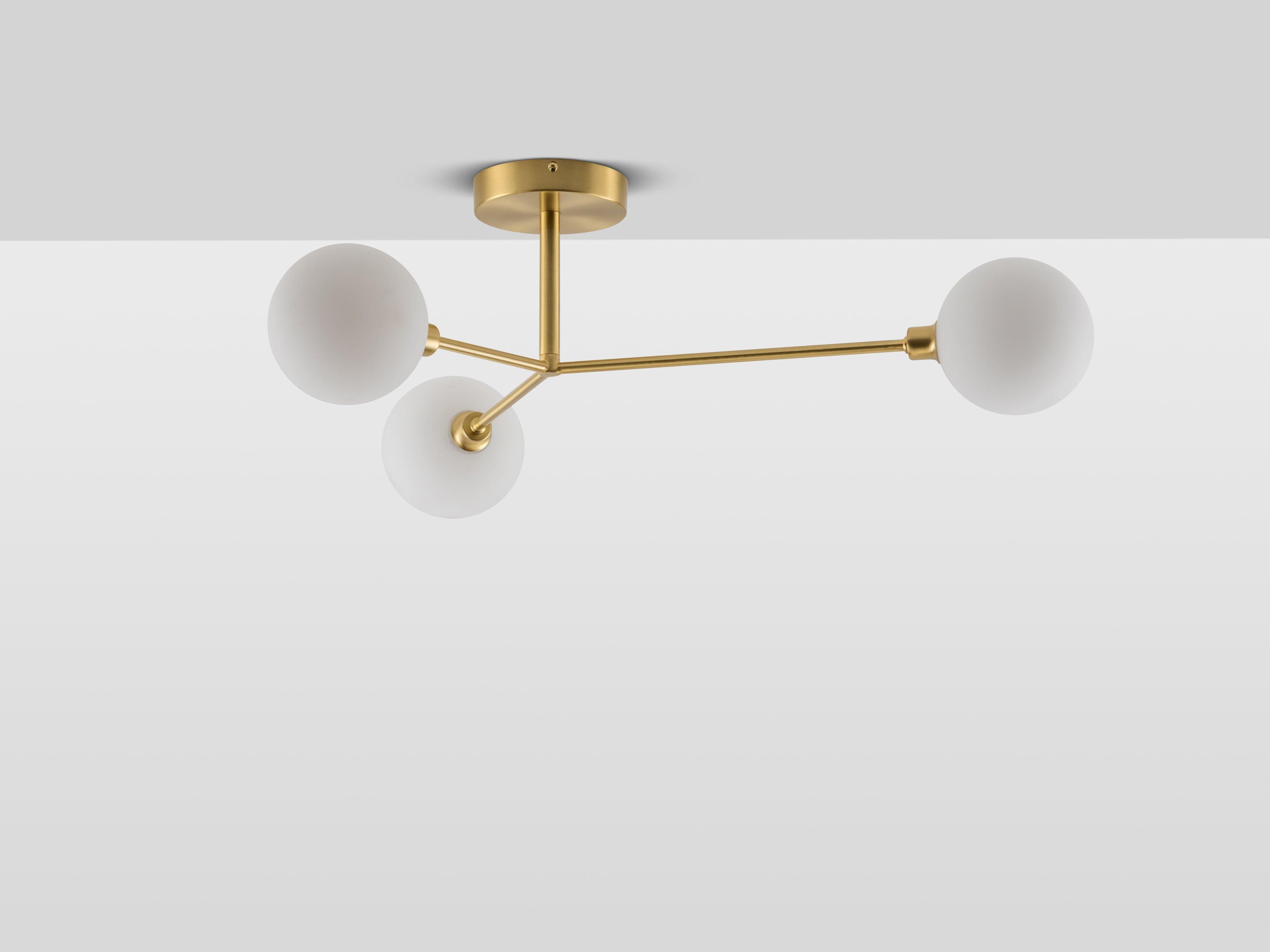 This contemporary ceiling light is the perfect statement piece. Three metal stems hold our opal glass shades, which diffuse a warm illuminating glow, reminiscent of sunshine. Ideal for a dining space or living room, this modern classic will add the
