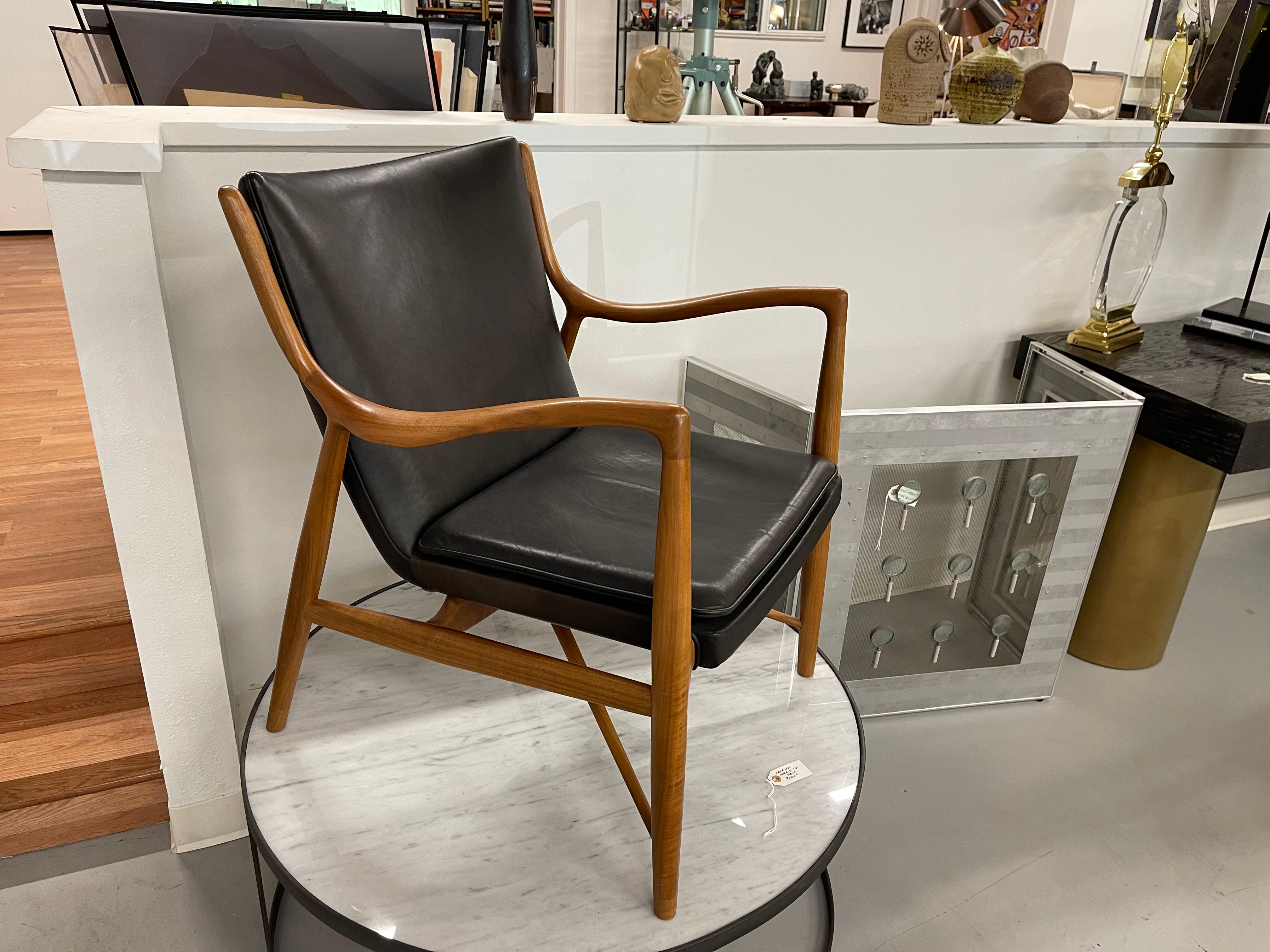 A House of Finn Juhl, one collection 45 chair in a high grade black leather. Has the house of Finn Juhl circular tag underneath. There are some marks to the frame and leather. There is a professionally repaired crack to one arm which is pictured. It