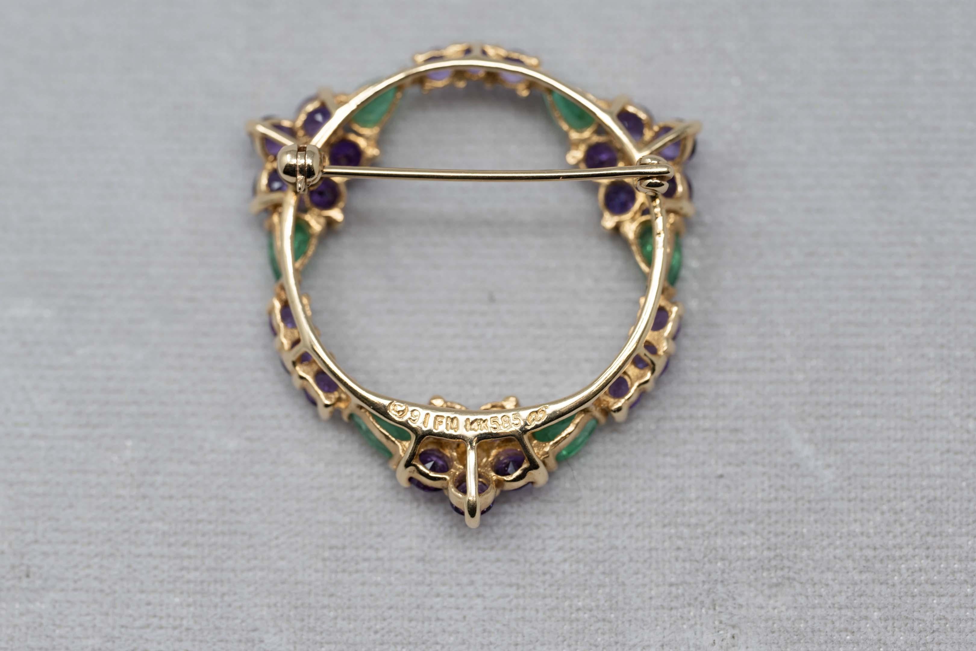 House of Igor Carl Faberge for Franklin Mint 14k yellow gold, brooch diamonds, emeralds and amethyst gemstones. Dated 91, marked 14k FM with Faberge mark. Measures 32 mm in diameter. 5.7 grams.
