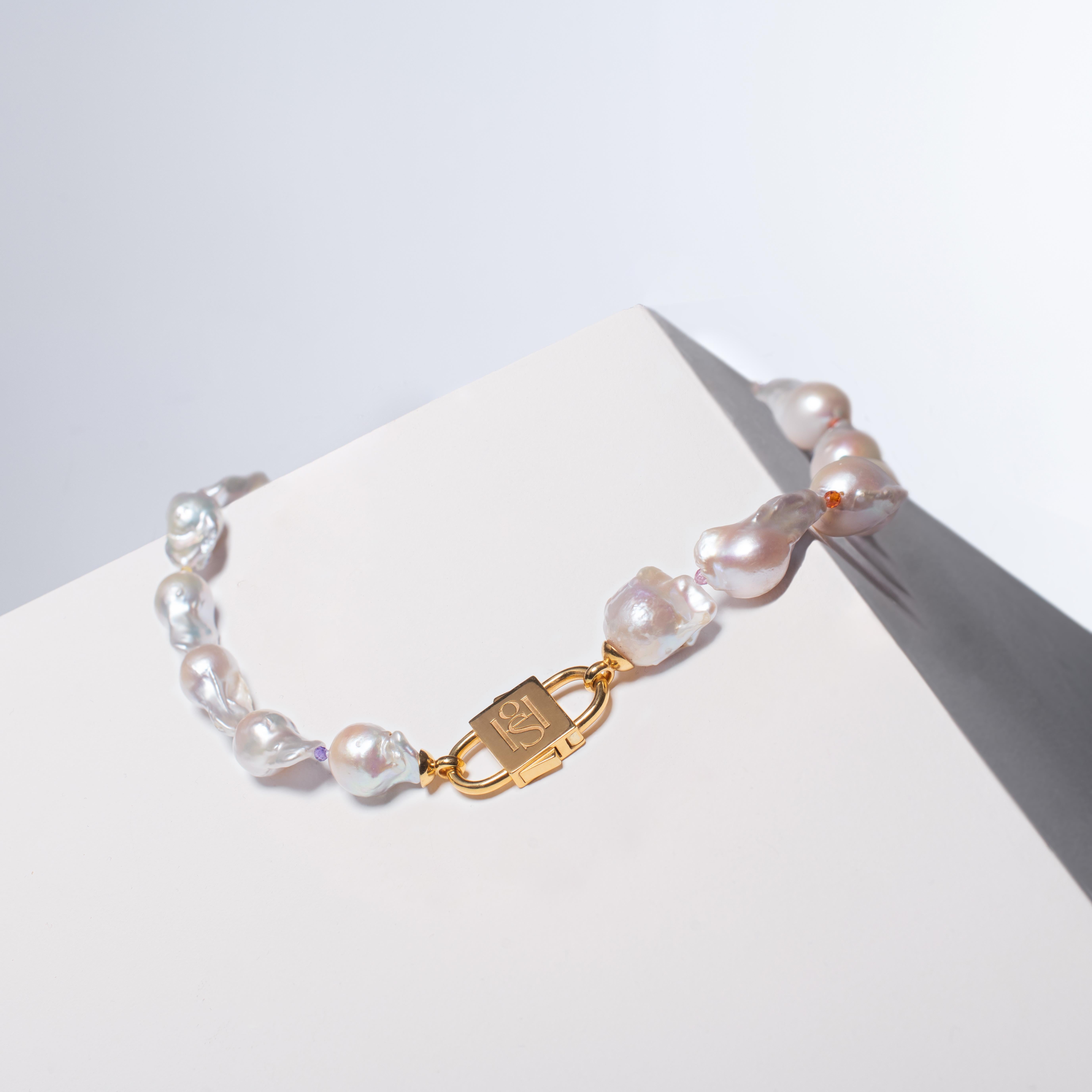 The House of Sol Baroque Pearl necklace combines classical baroque pearls with vibrant semi-precious gemstones like tourmaline and citrine. It is versatile, suitable for day and night, and complements any style. Handcrafted with precision and