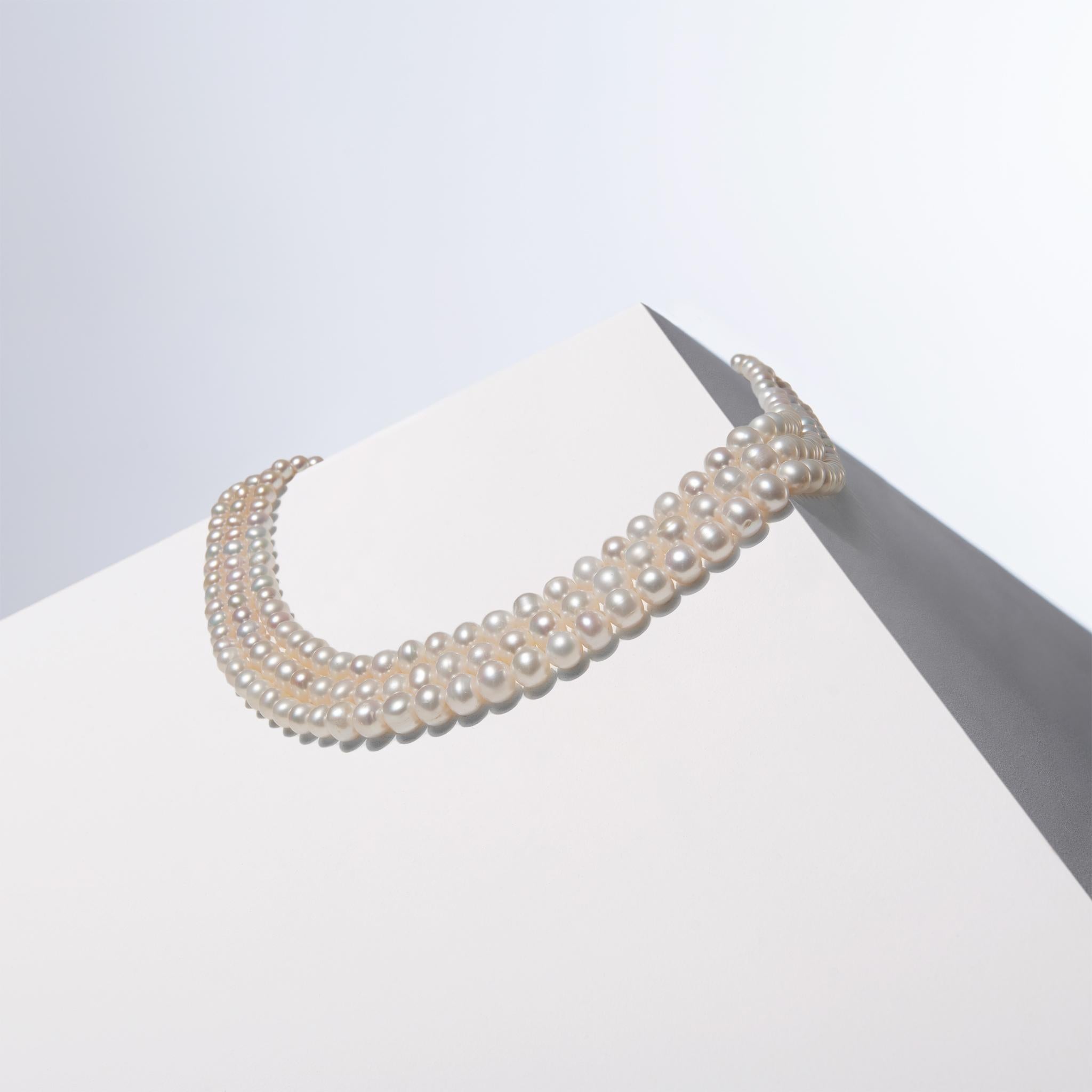 This handcrafted triple-strand pearl necklace features graduating pearls, ranging from 6mm at the ends to 9mm at the center. The intentional selection of pearls creates a textured look, enhancing depth and dimension. Wearers can choose to wear one,